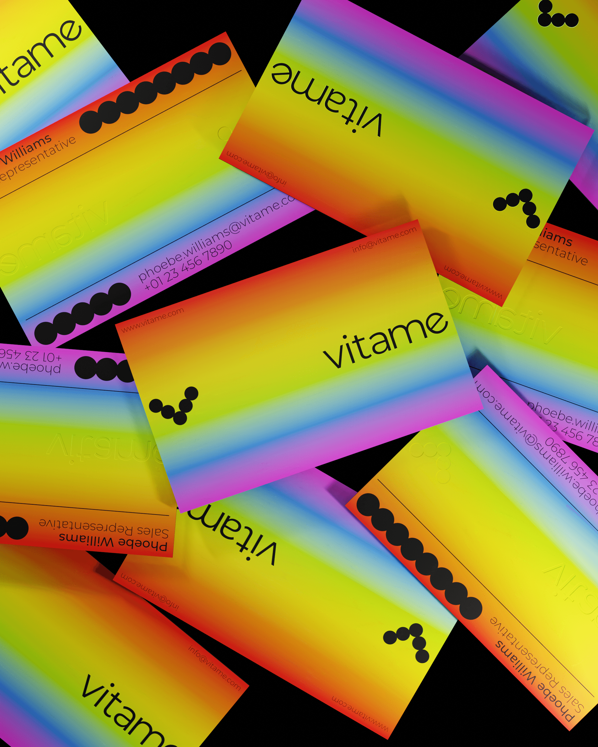 A mockup of Vitame's business card design. The cards feature a vibrant gradient background with the brand's logo and contact details printed on them in black.