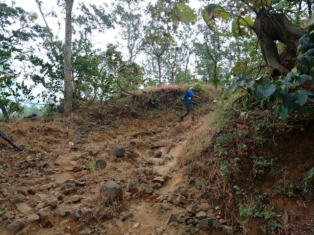 A trekker climbing up the rocky path to Naneghat