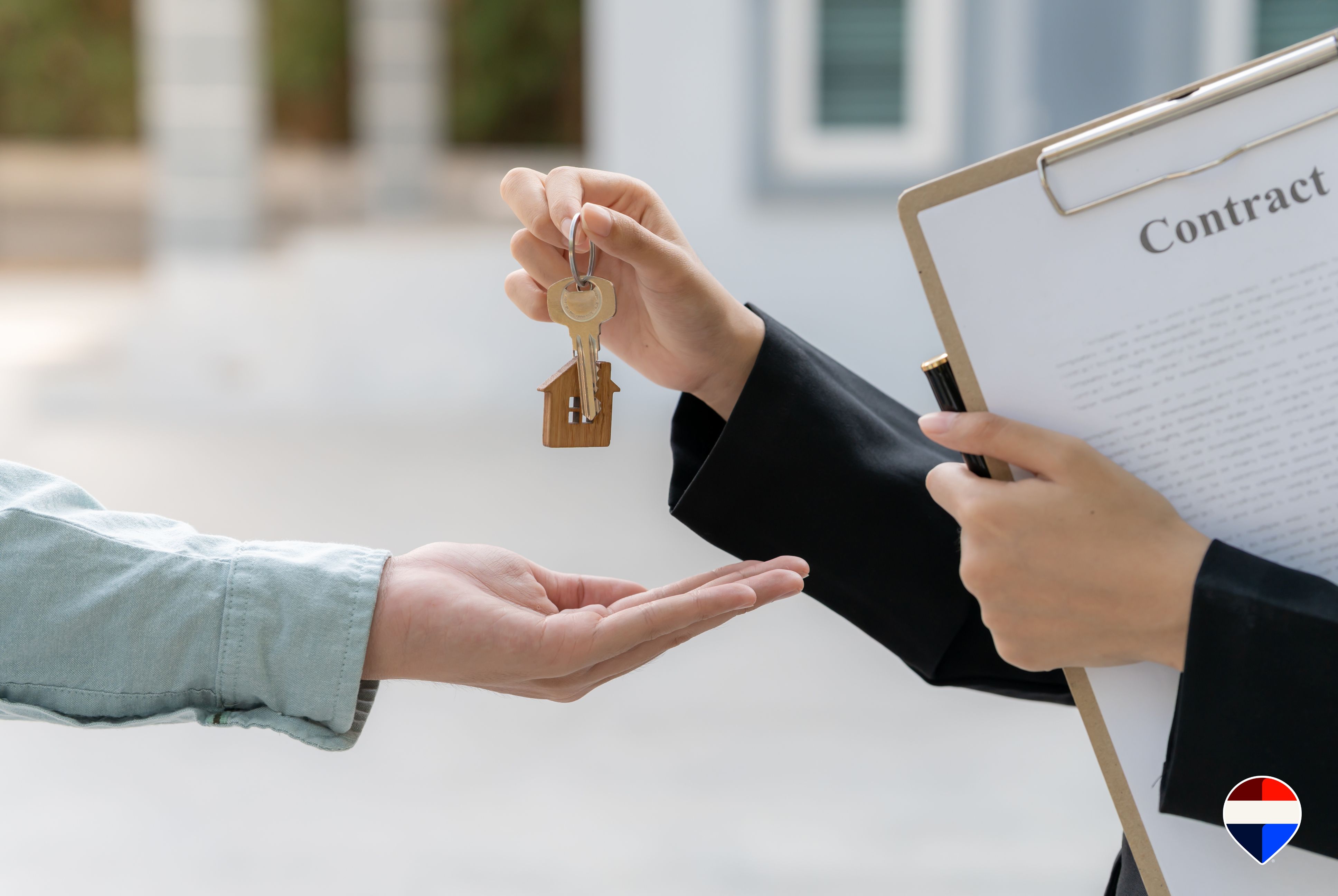 Agente immobiliare che consegna le chiavi di casa all'acquirente dopo la firma del contratto di compravendita