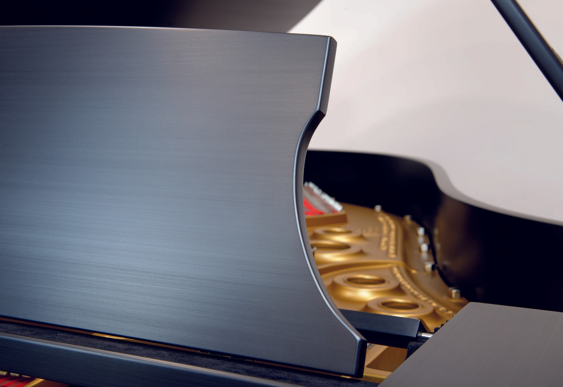 A close-up shot of the interior lid and golden plate of a restored Steinway & Sons grand piano, emphasizing the luxurious restoration.