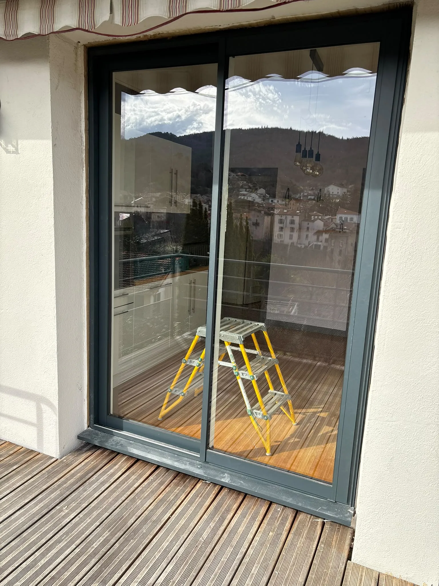 Baie vitrée donnant sur une terrasse en construction — AFermetures