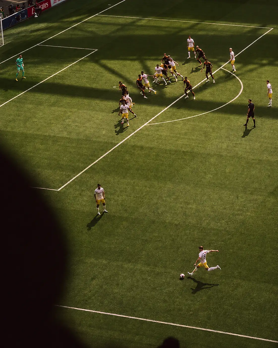 Aerial view of a football match with players competing near the penalty area