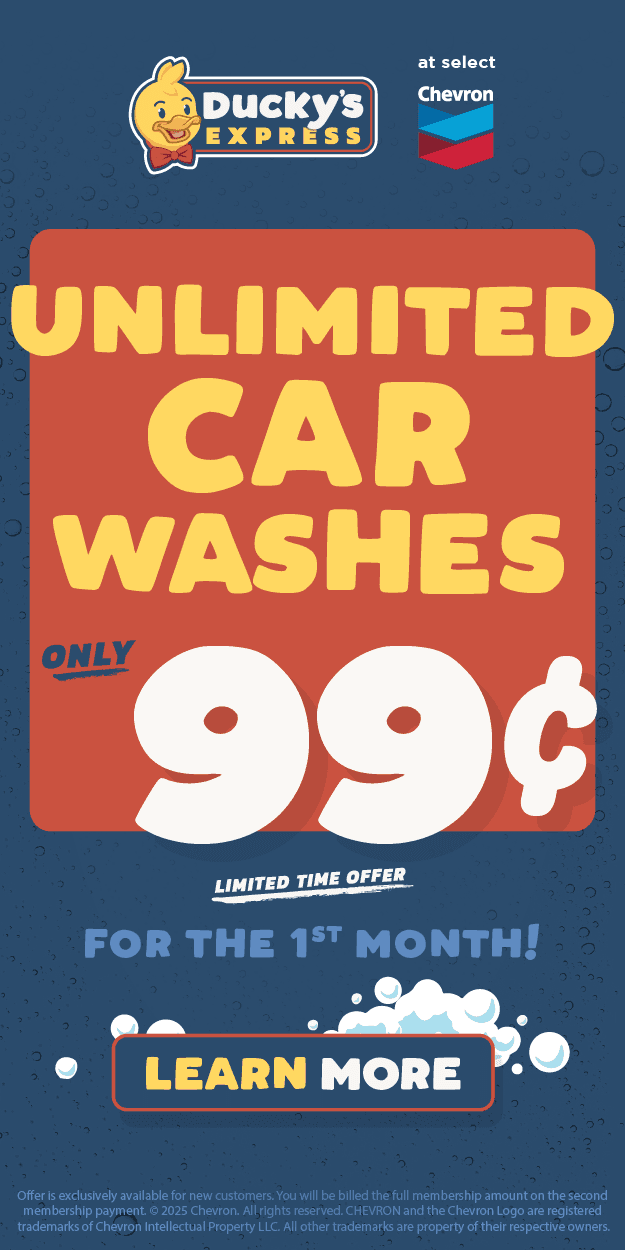 Black and white photo of two people looking at a computer screen with papers on wall