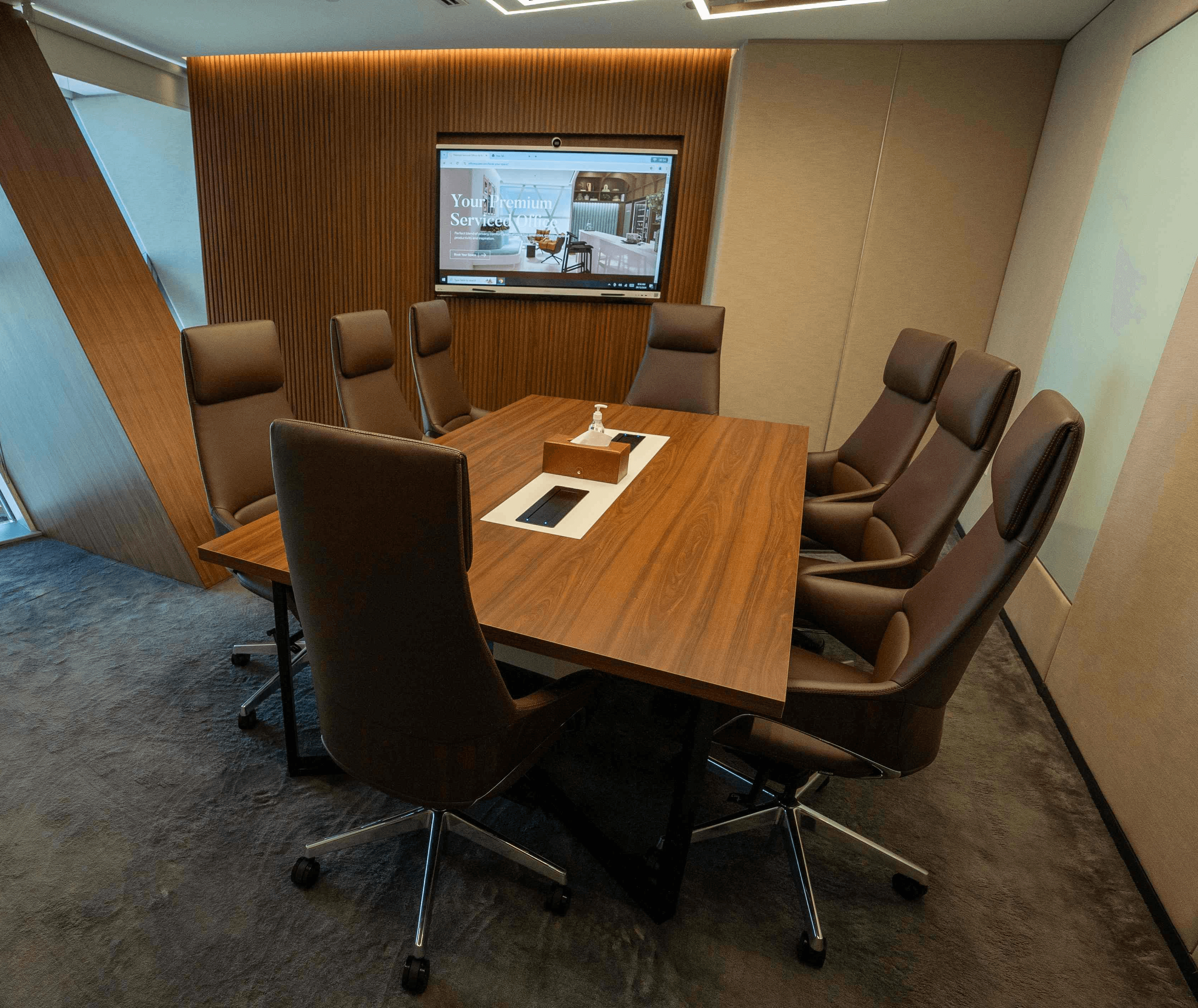 A sophisticated private meeting room with warm lighting, a refined wooden table, and executive chairs.