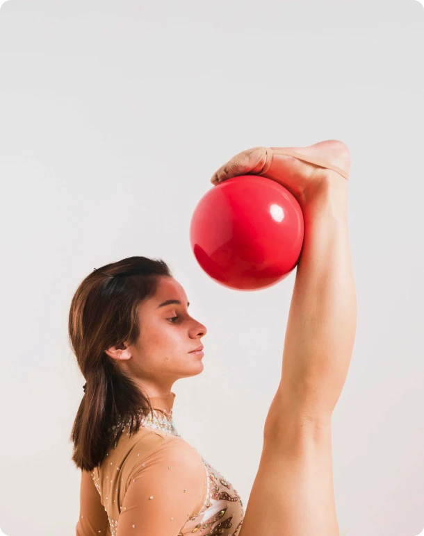 Rythmic gymnast posing with the ball