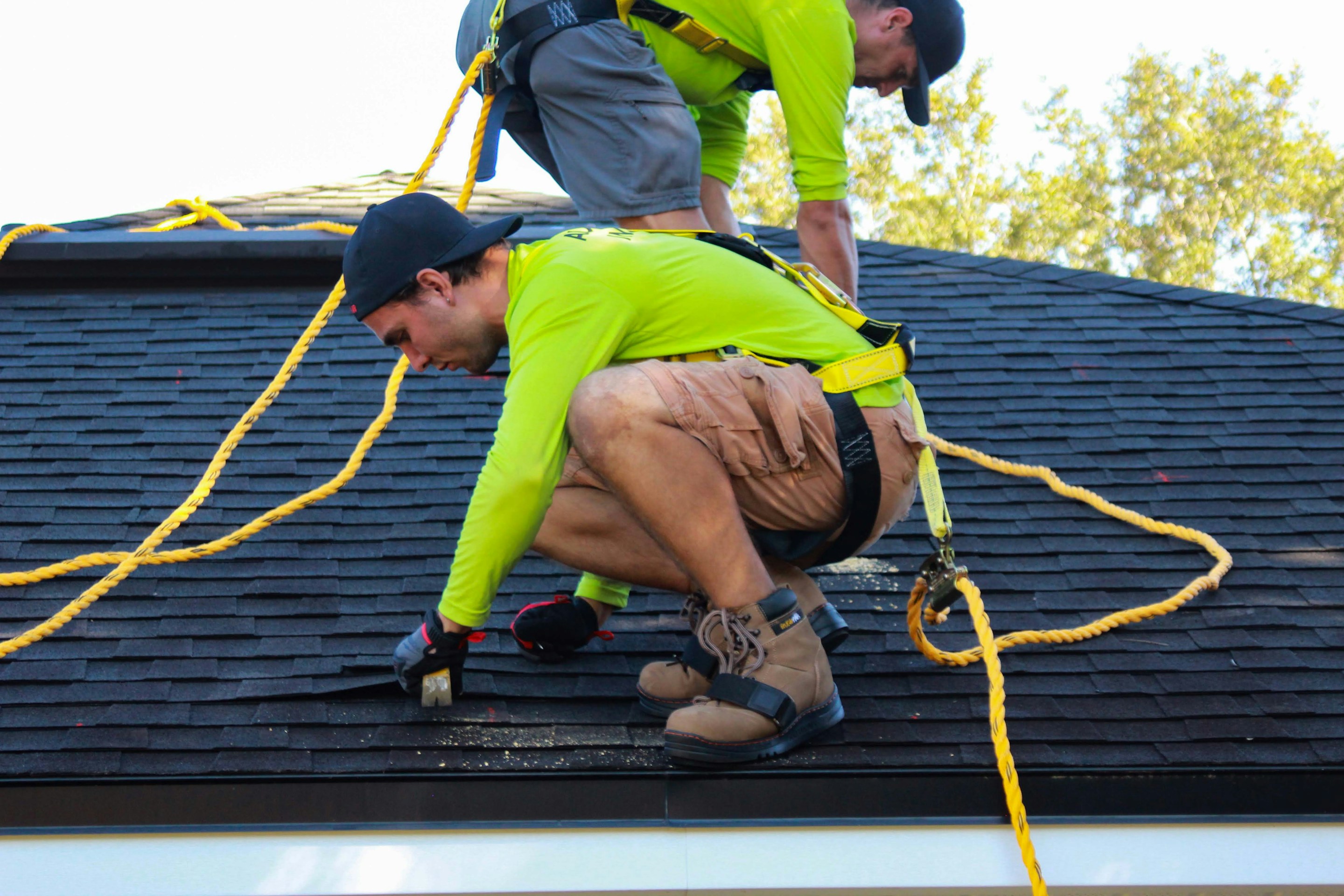 Two roofers carrying out repairs on a residential roof