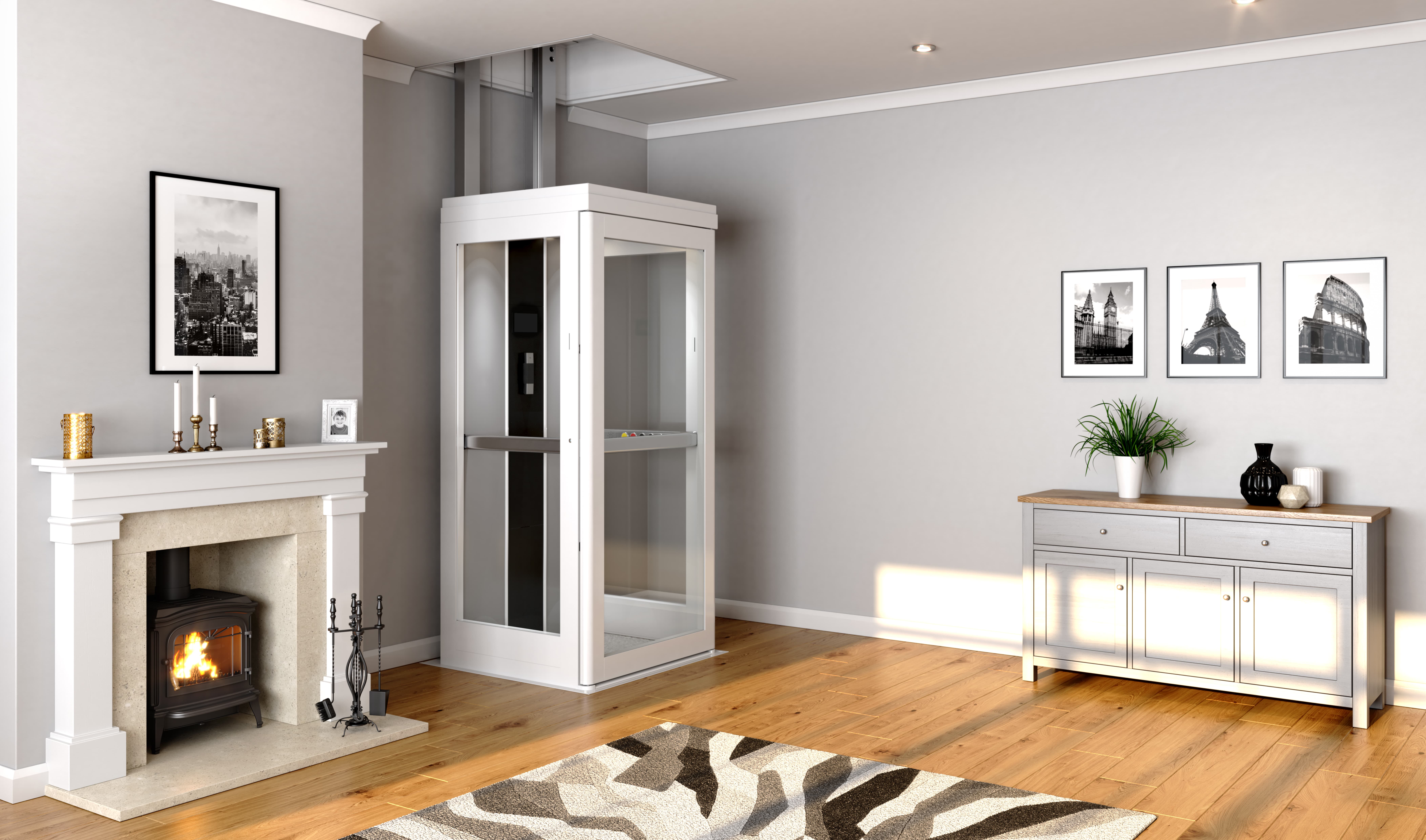 A white glazed through-floor home lift installed in a residential living room, with a fully enclosed cabin, control panel, and handrail visible, rising through the ceiling between floors.