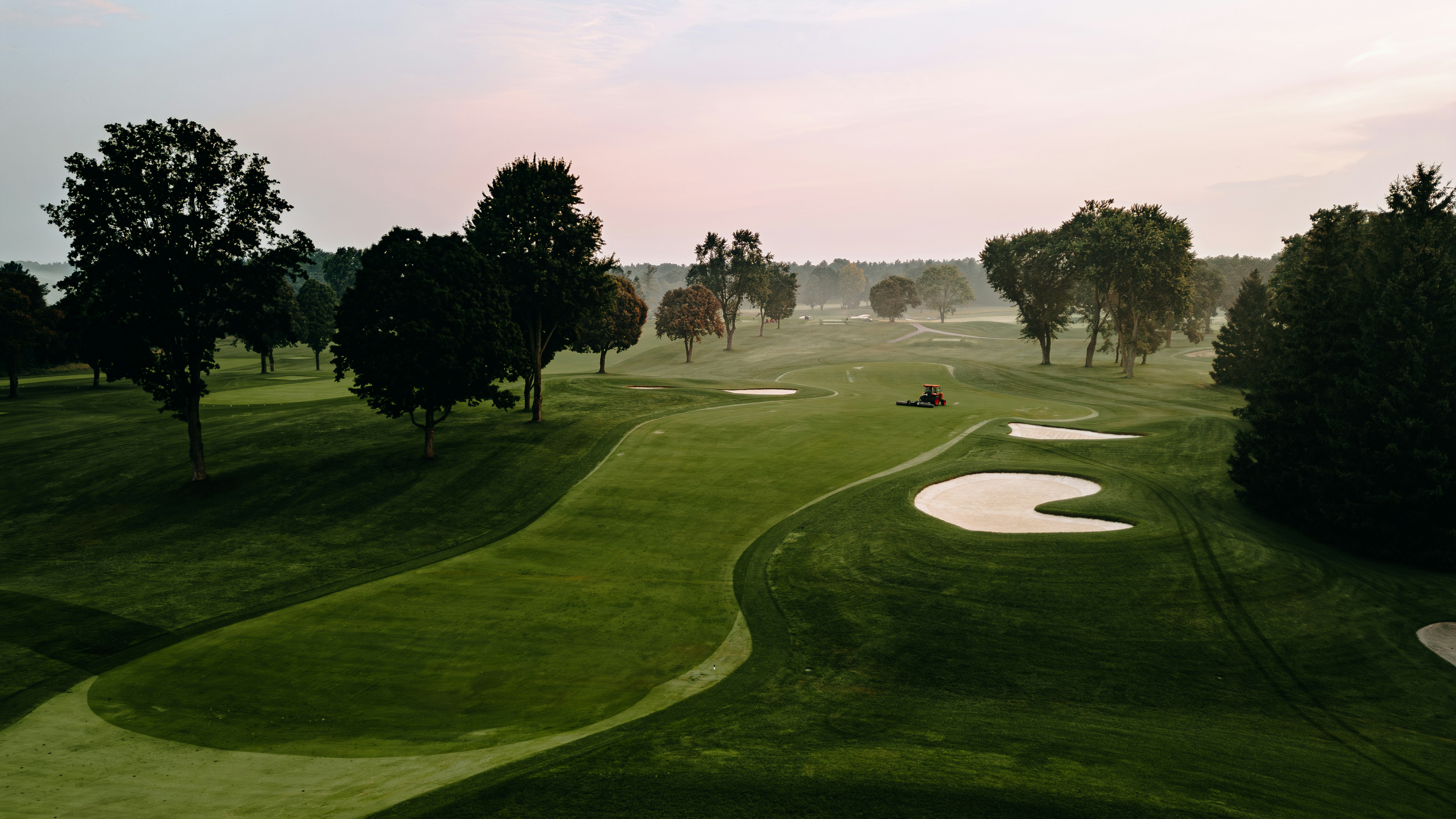 A golf course is surrounded by trees.