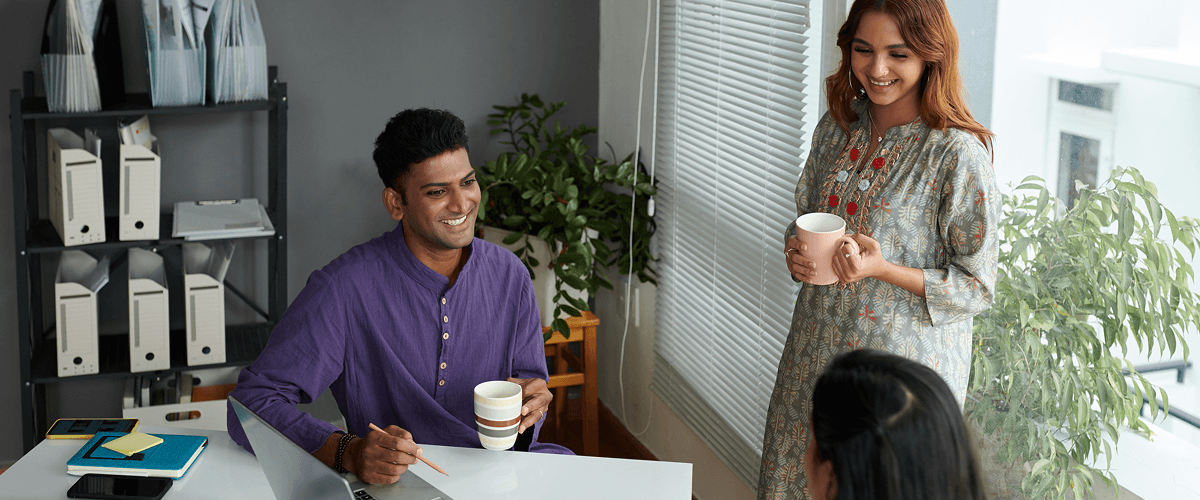 Business colleagues smiling and watching a company culture video representing the common traits of great company culture videos.