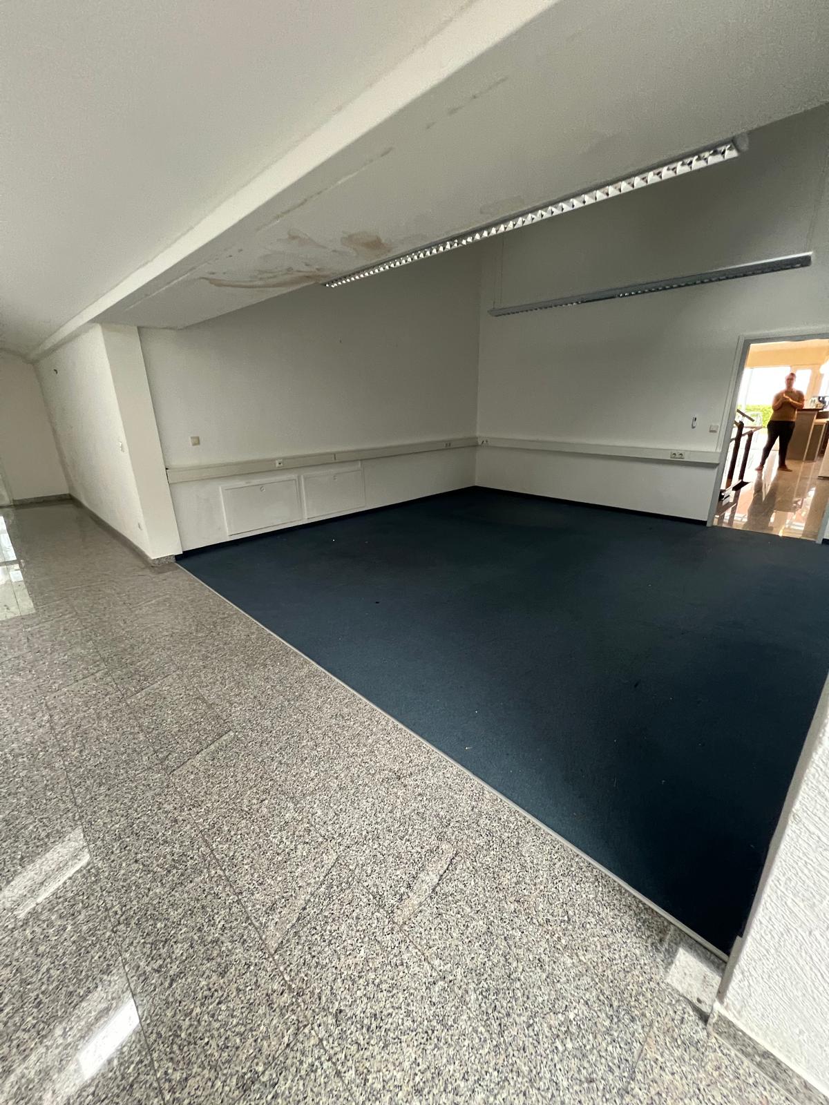 Entrümpelung Freising ein Mann ist an der Wand angelehnt und Grinst in die Kamere, Es scheint so als ob der Keller Entrümpelt wurde.