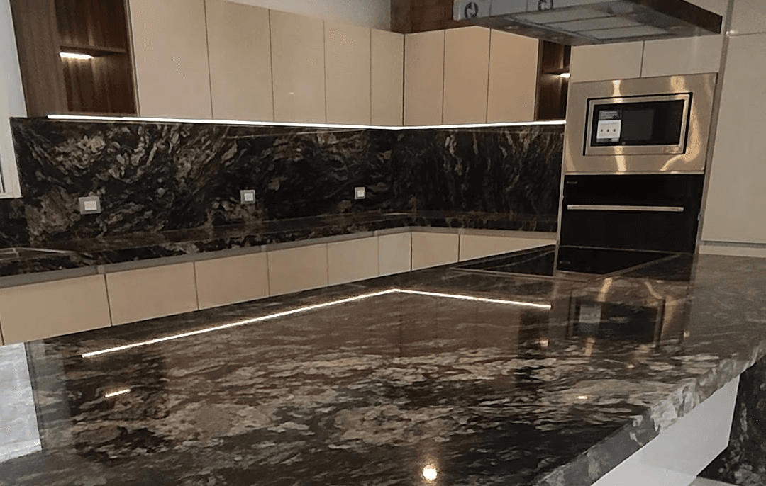 Modern indoor space with large glass doors, lush greenery, and a cozy seating area visible beyond.