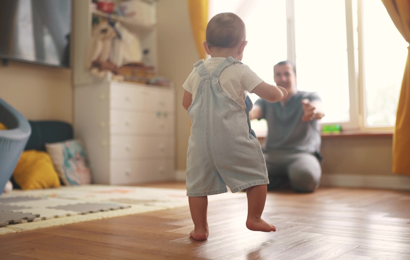 baby walking towards his father