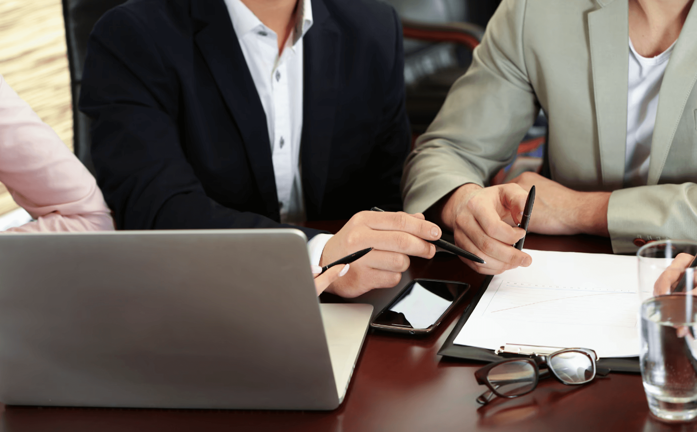 two people sitting at a desk with a document in front of them