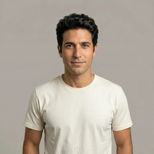 דיוקן של גבר ישראלי צעיר בשנות ה-30 לחייו, עם שיער שחור ומראה מגולח, לבוש בטי-שירט לבנה ונקייה על רקע אפור אחיד. תמונת לקוח מרוצה עבור עמוד ההמלצות של אתר עלונים.