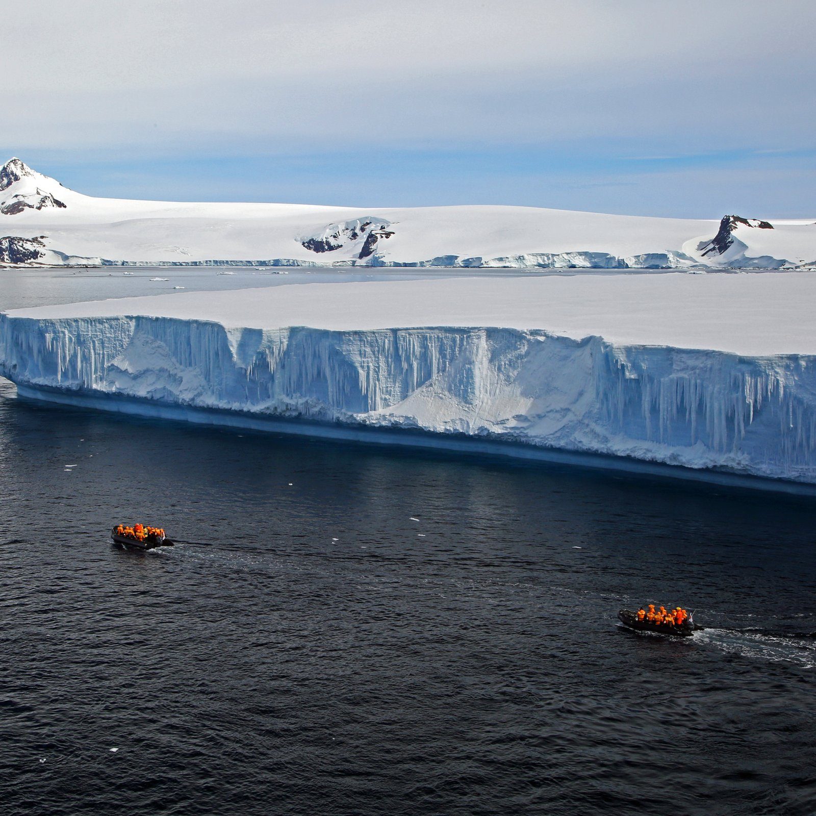 An expedition ship on still water amid ice and mist, Antarctica.