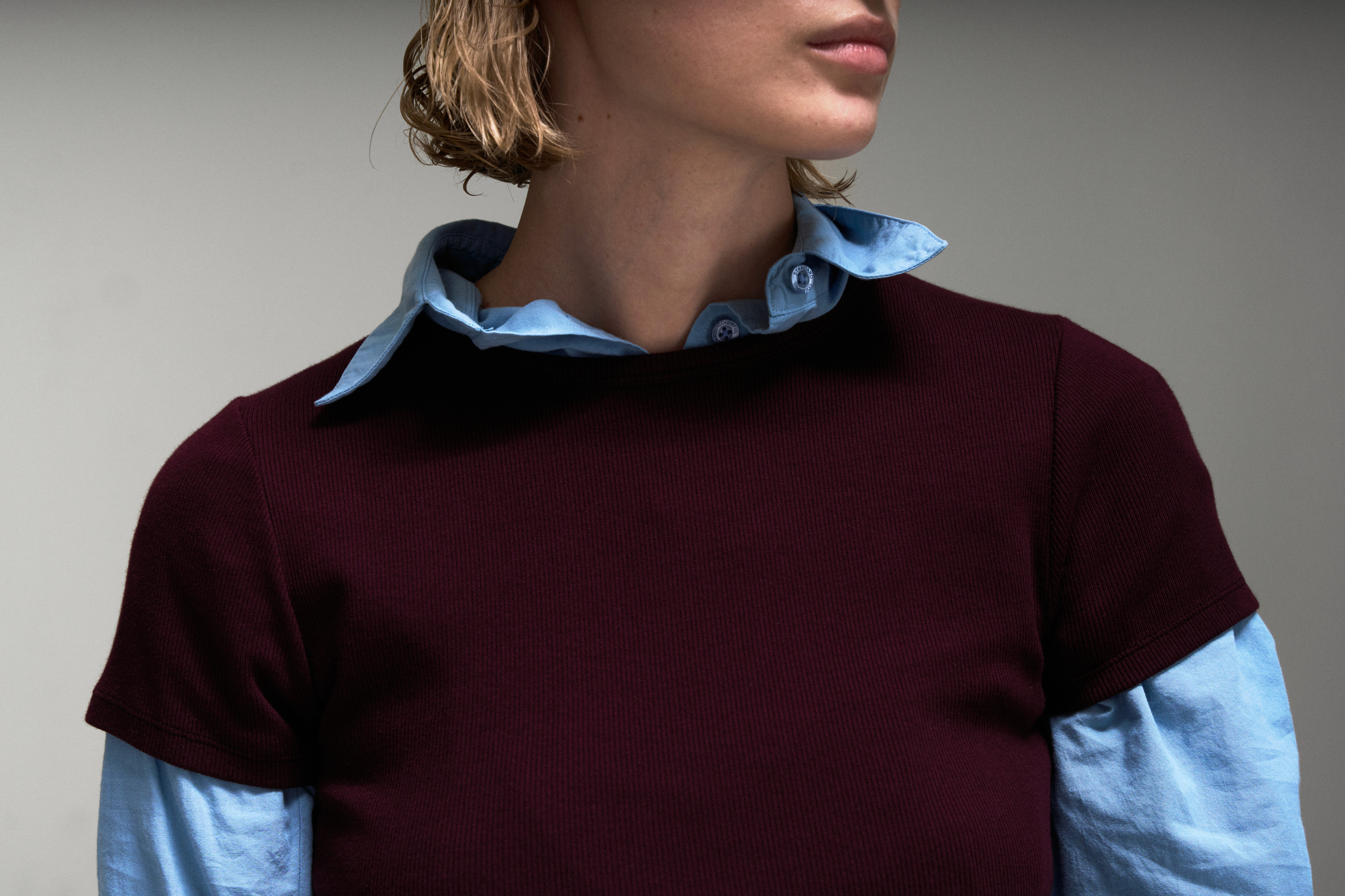Détail dans le lookbook Colorful Standard avec chemise bleu ciel et t-shirt bordeaux