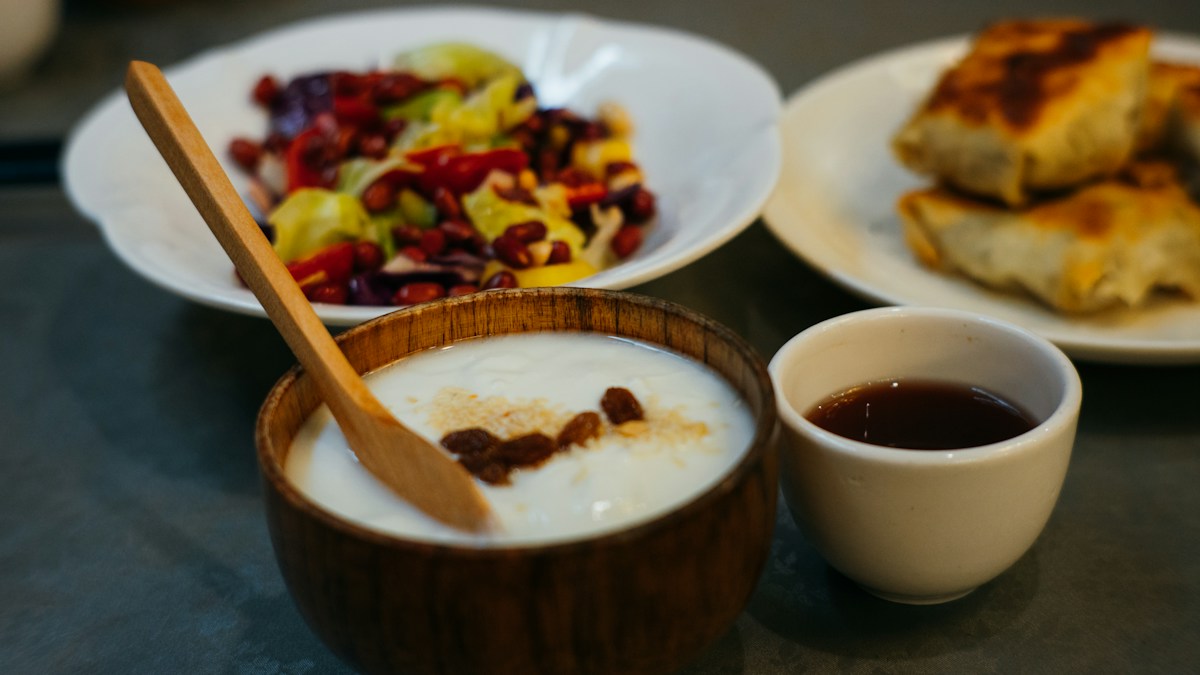 A bowl of yogurt with live cultures served alongside fermented vegetables, a food-first source of probiotics.