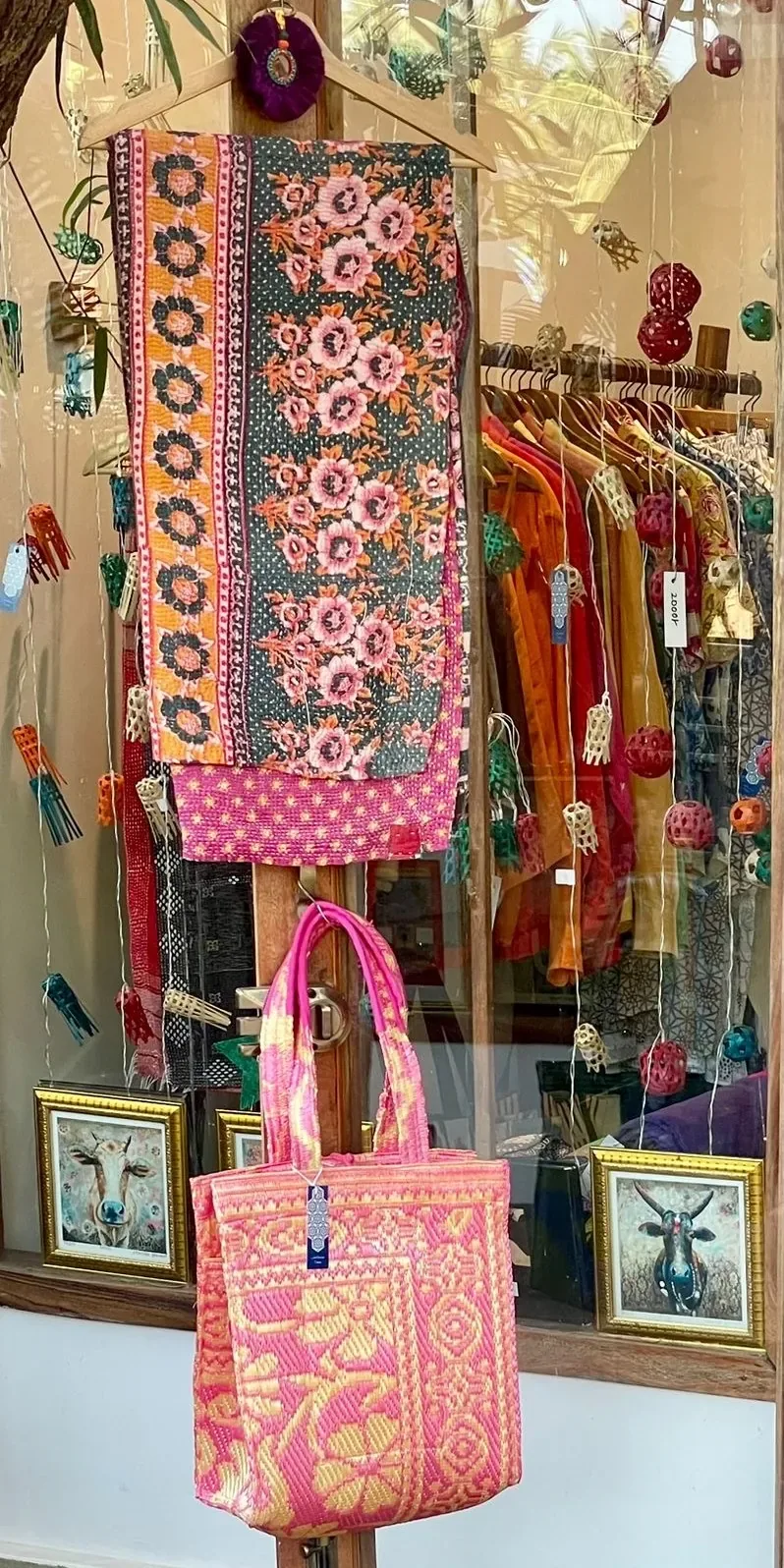 Pink block-print quilted tote and floral kantha throw in the boutique window at Jaali Boutique
