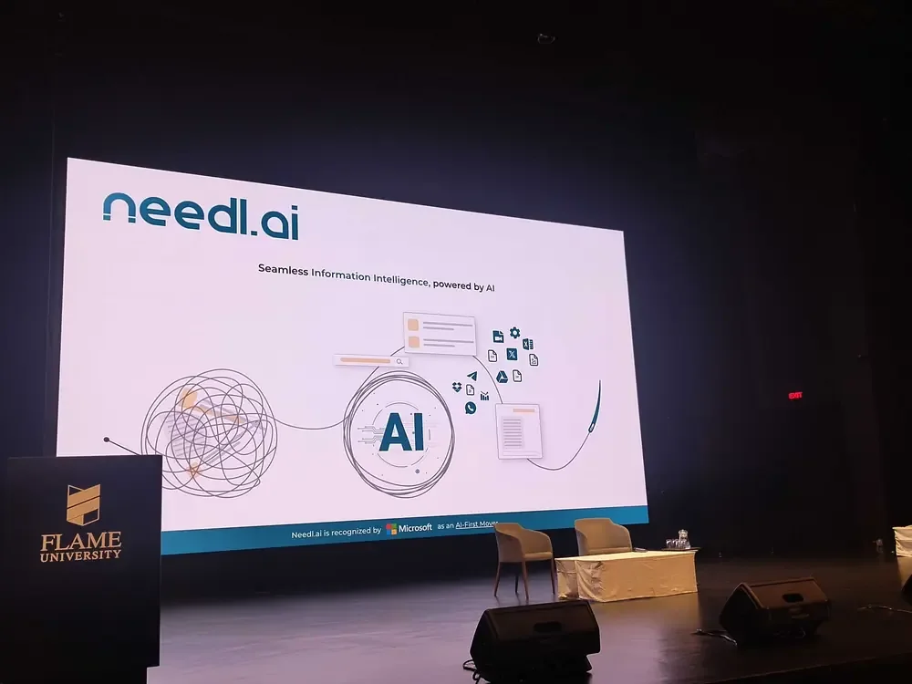 A Needl.ai slide on stage at FLAME University
