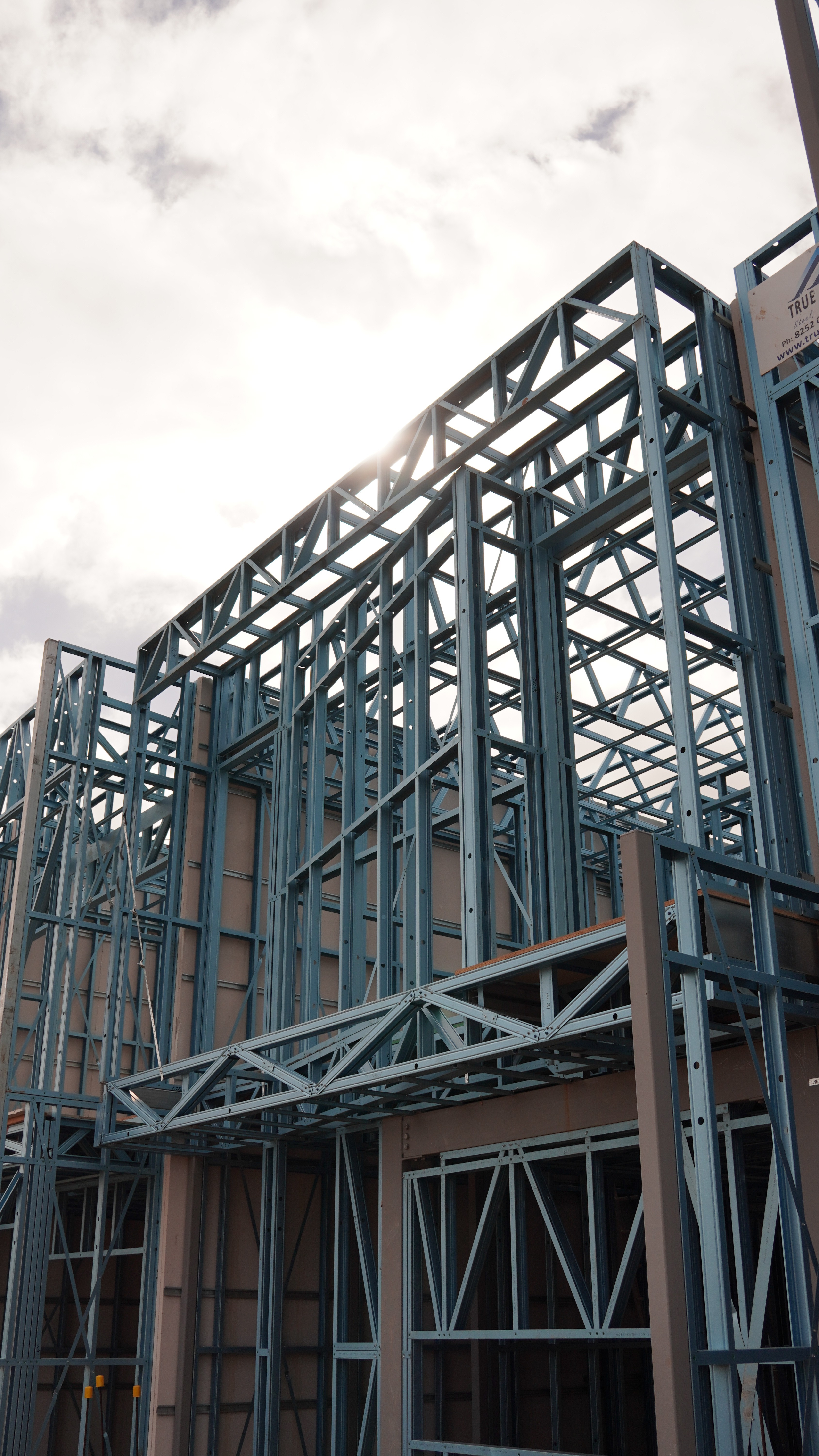 Smiling young man with short hair poses against a dark background, wearing a green button-up shirt.