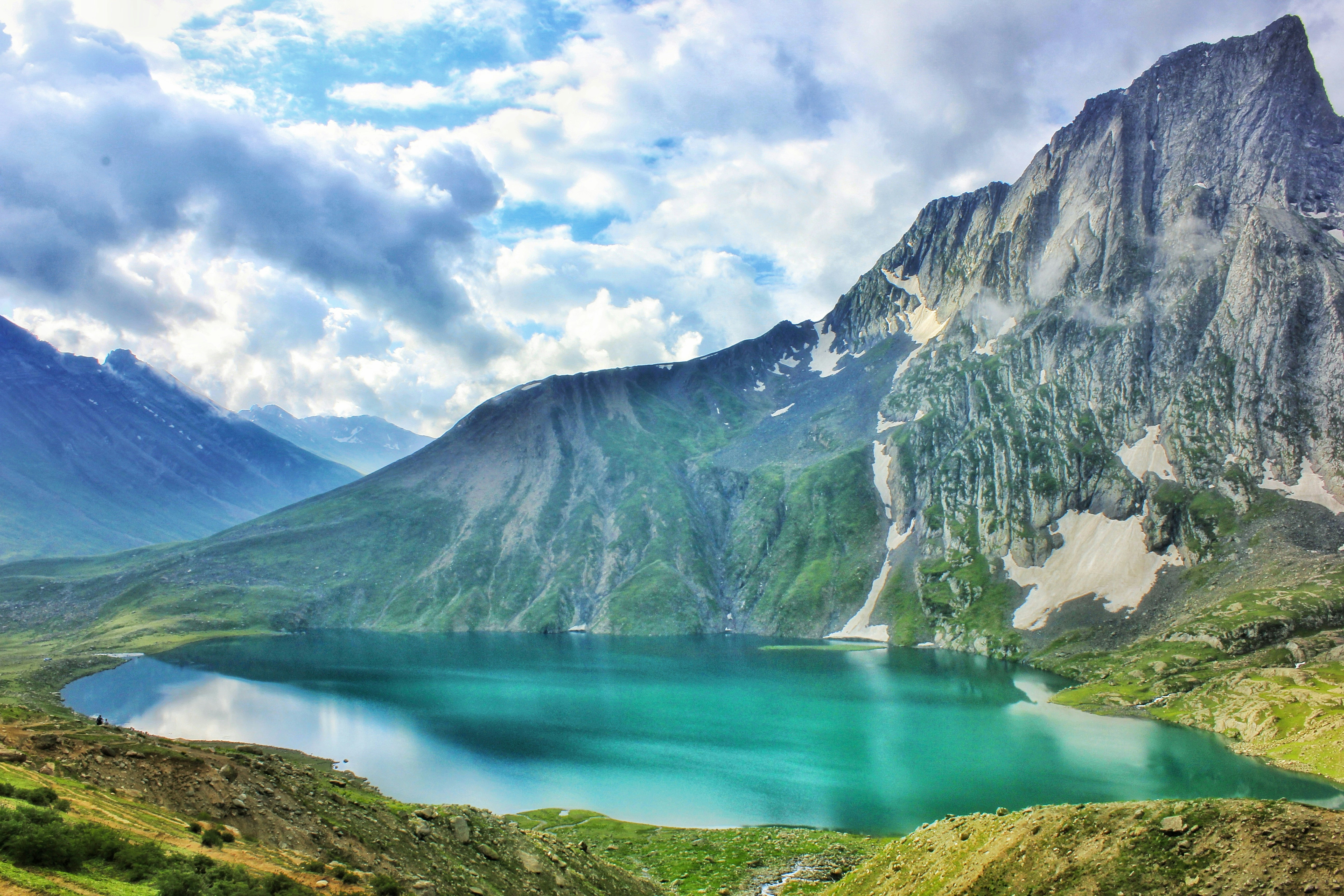 lake and mountain under cloudy sky