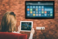 Person watching TV while looking at iPad