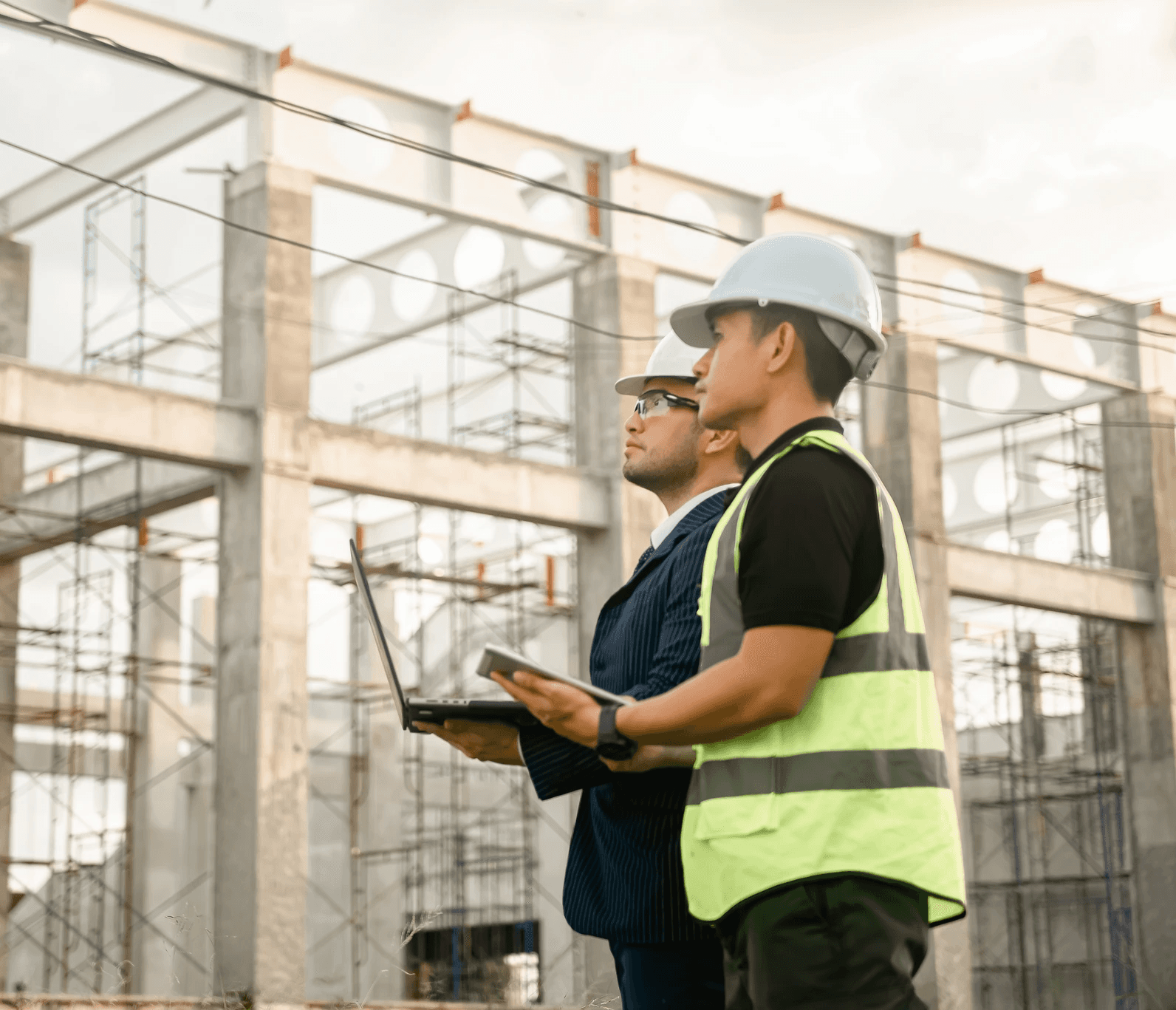 Zwei Männer mit Schutzhelmen und Arbeitskleidung auf der Baustelle eines Wohnvision-Projekts
