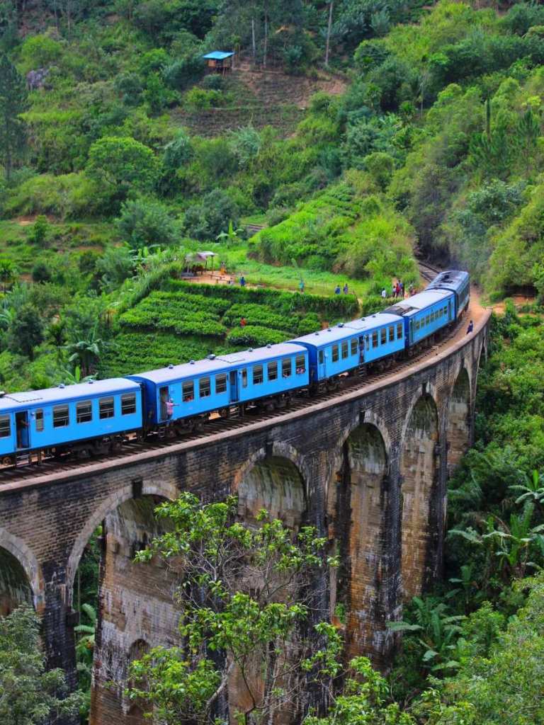 A blue train crossing the iconic Nine Arch Bridge in Sri Lanka - adventure destinations