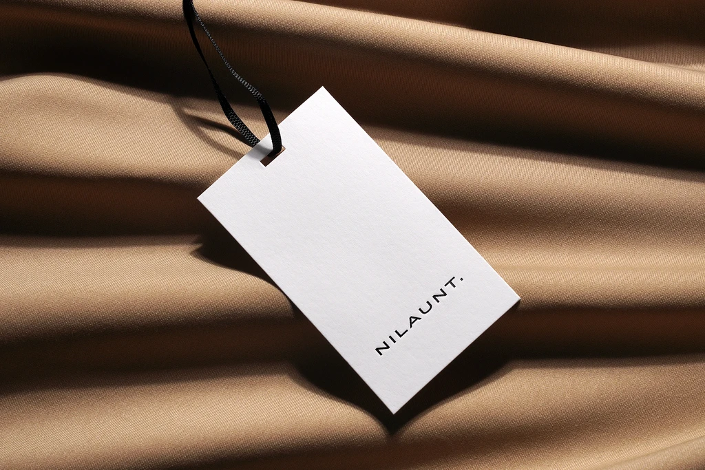 Minimalist wrinkled clothing tag mockup attached to fabric.