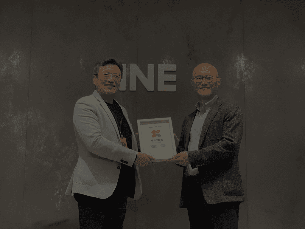 A modern house with large windows and a flat roof, surrounded by greenery against a clear blue sky.