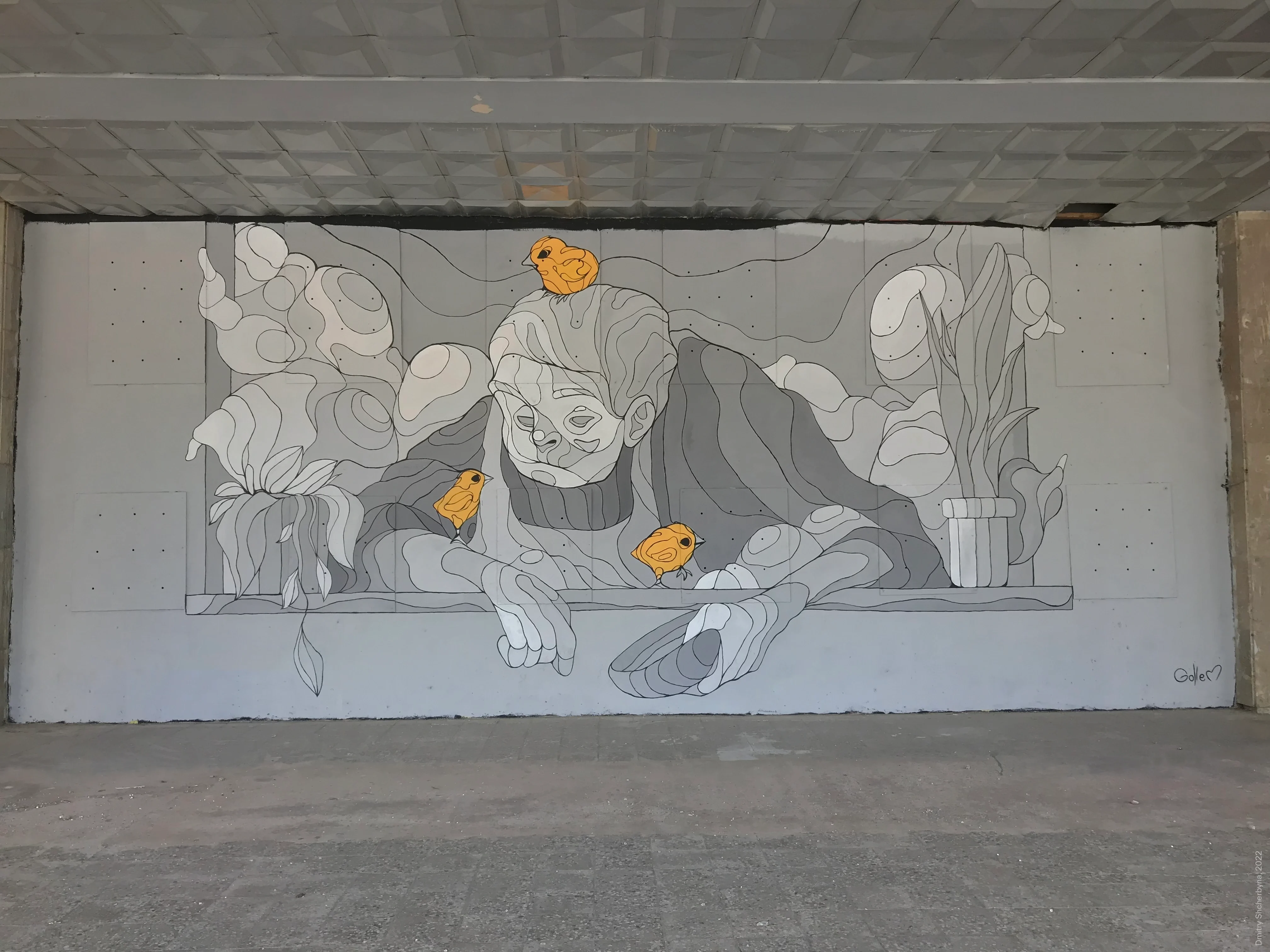A monochrome grey mural depicts an elderly person leaning on a ledge with his hands, while three small orange chicks perch on and around him.