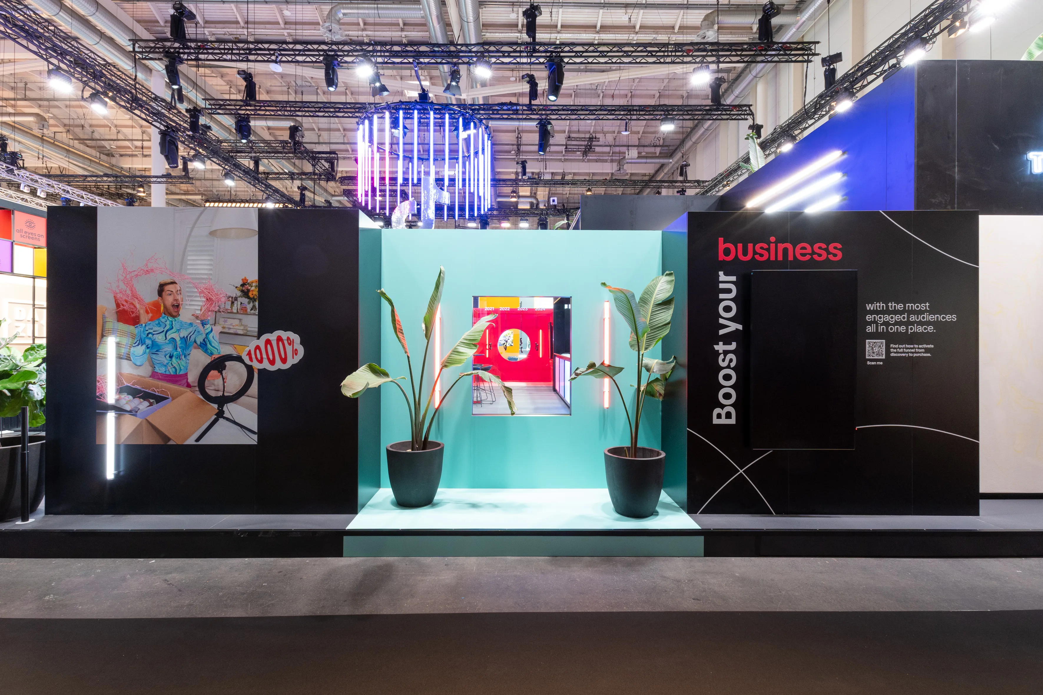 Mint-green photo niche with plants between dark walls and Boost Your Business panel at the TikTok booth.