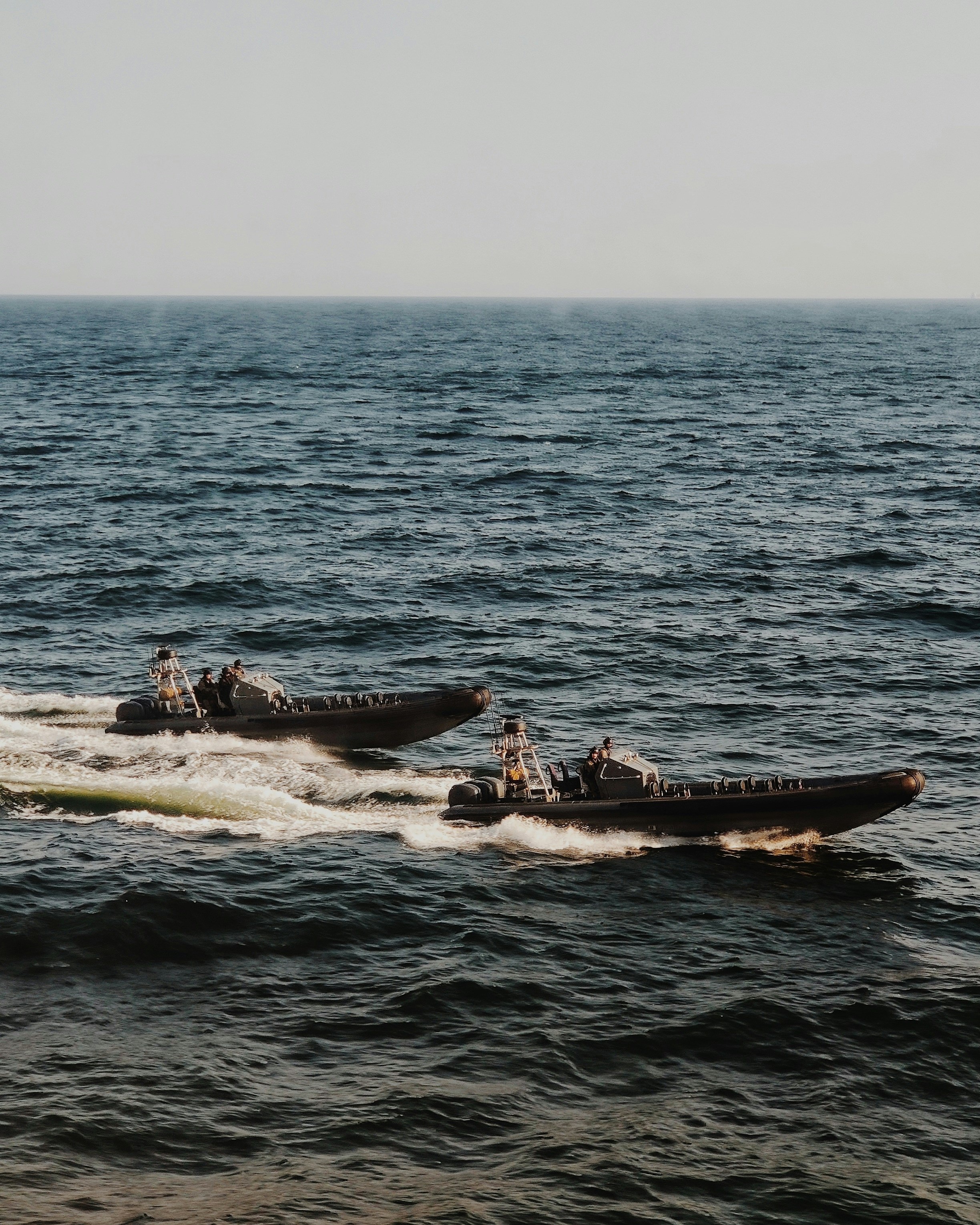 people riding on white and black boat on sea during daytime