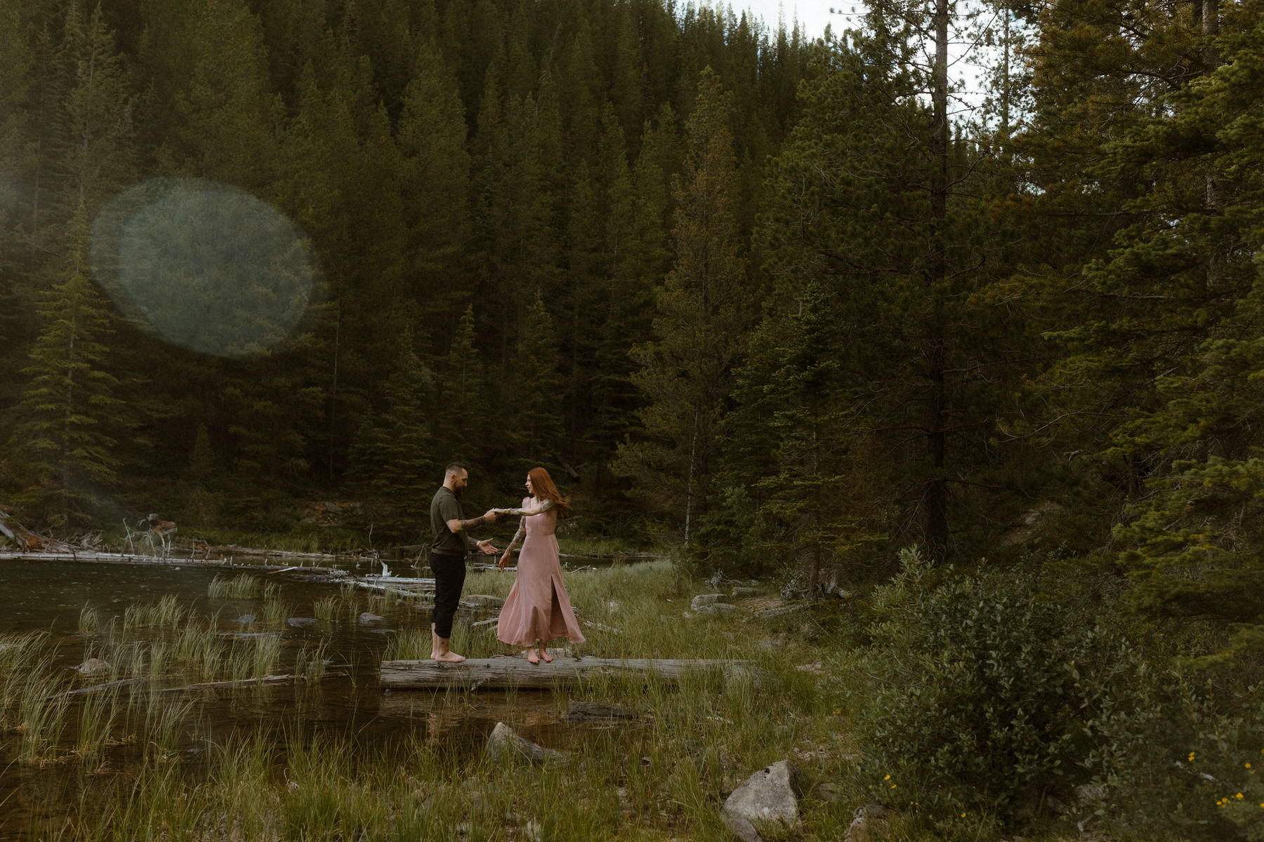Wedding couple under veil with sunlight illuminating brides ice blue eyes