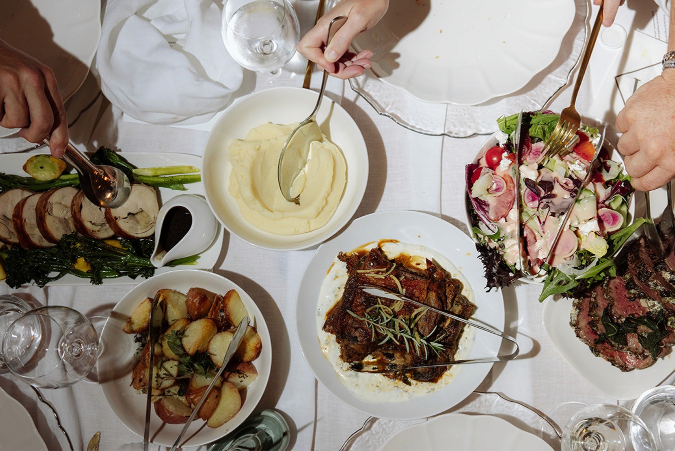 Shared Dining feast shot from above as guests reach for items