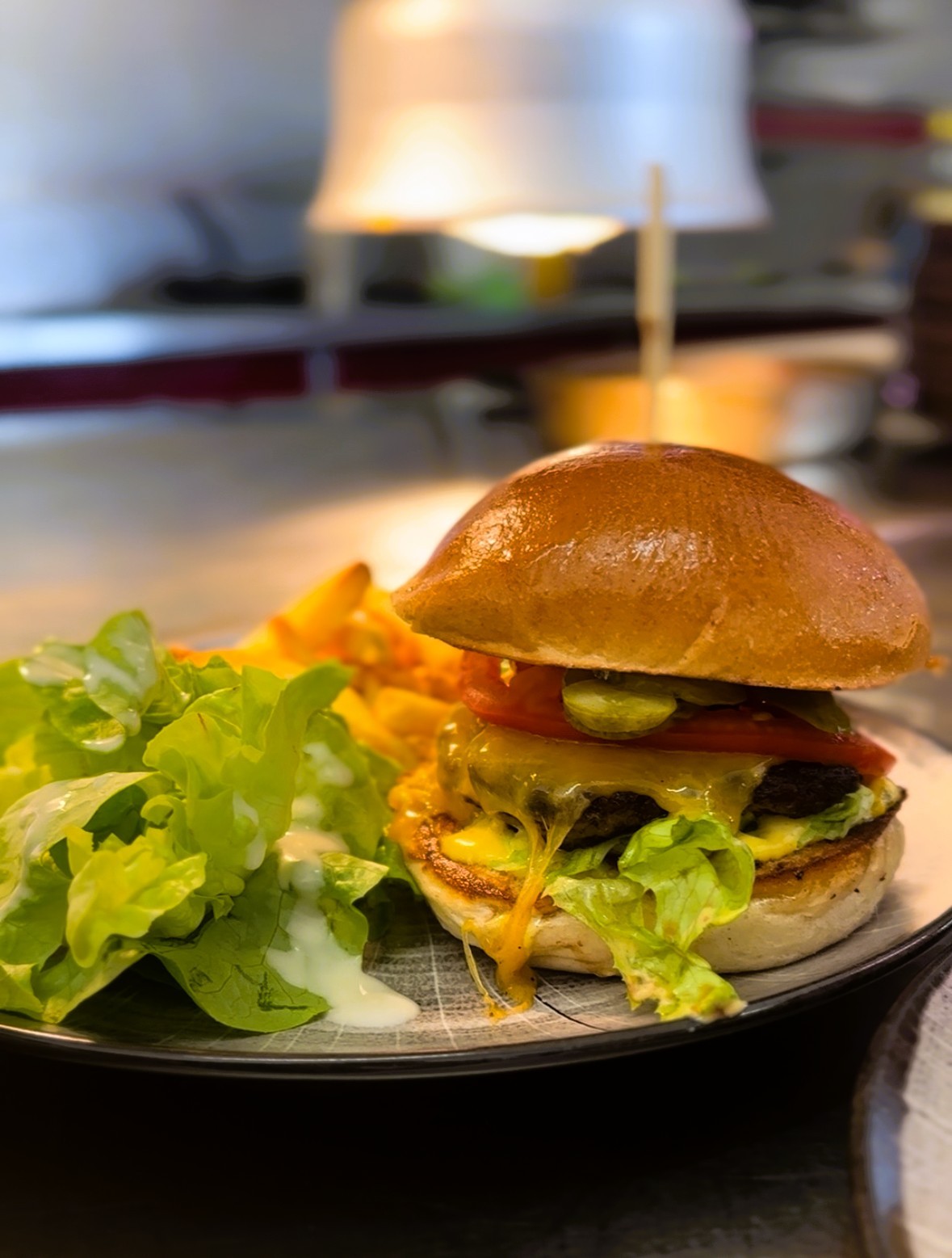 cheeseburger servi avec frites maison et salade verte
