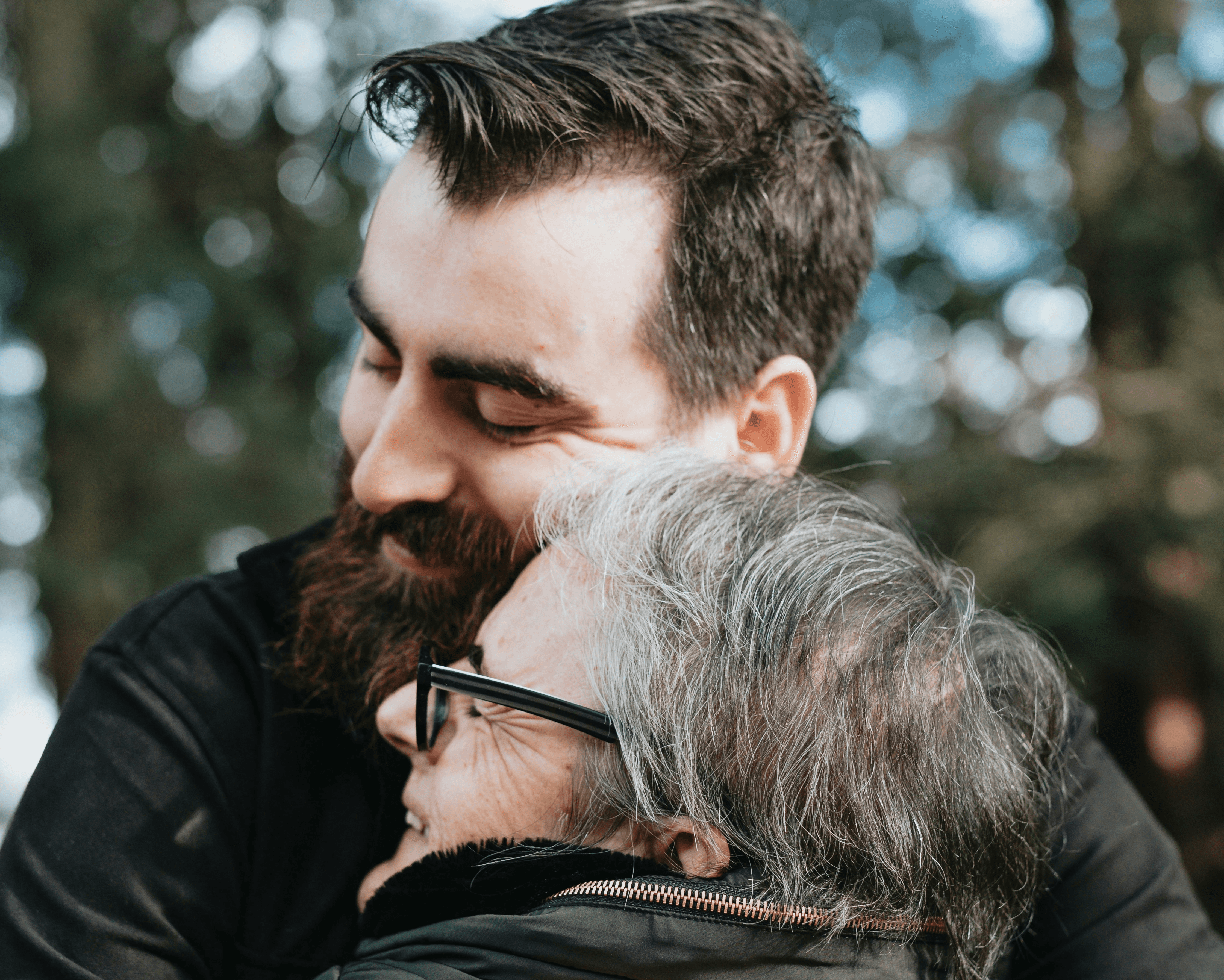 man hugs elderly woman