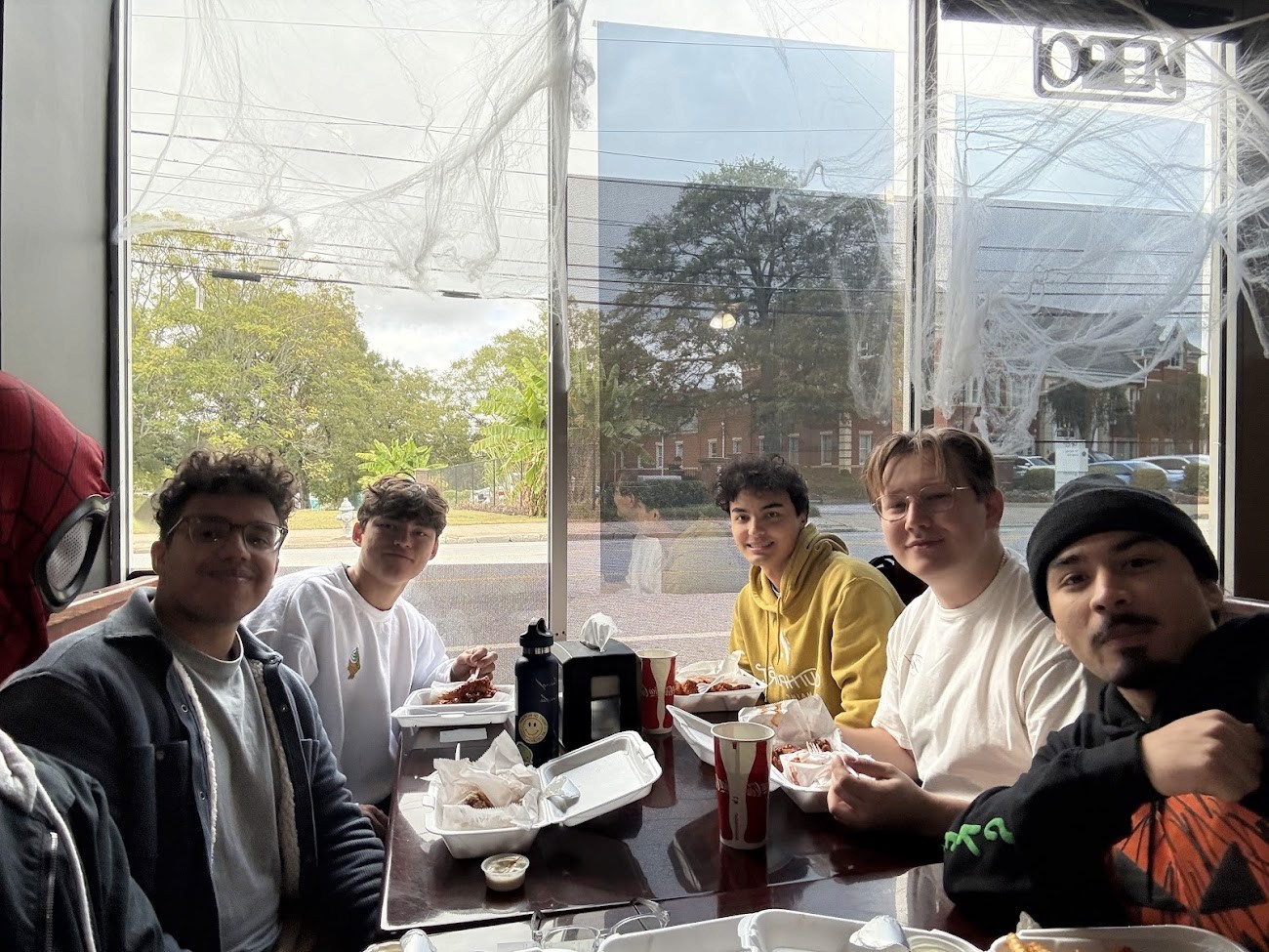 Silver "STUDIO" sign on a brown wooden slatted wall.