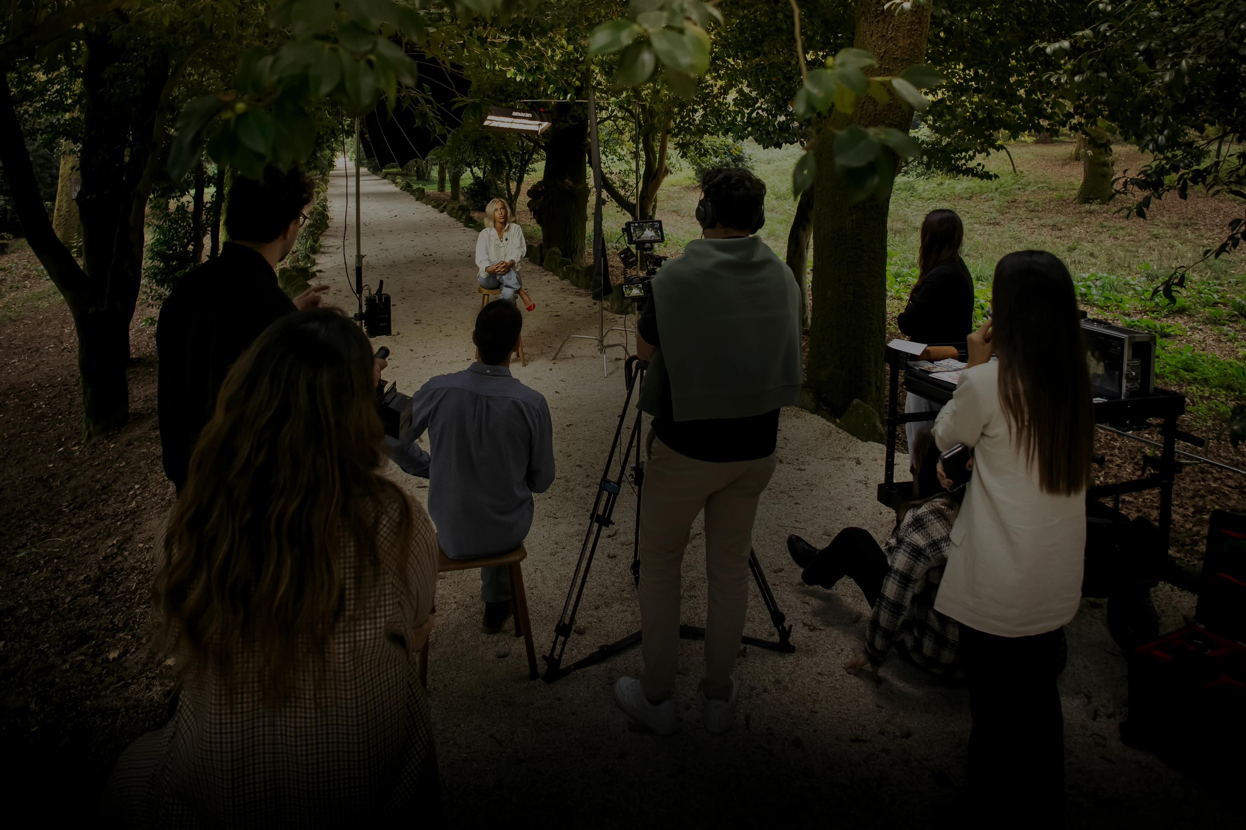 A silhouette of a person wearing sunglasses, with tousled hair, against a teal background.