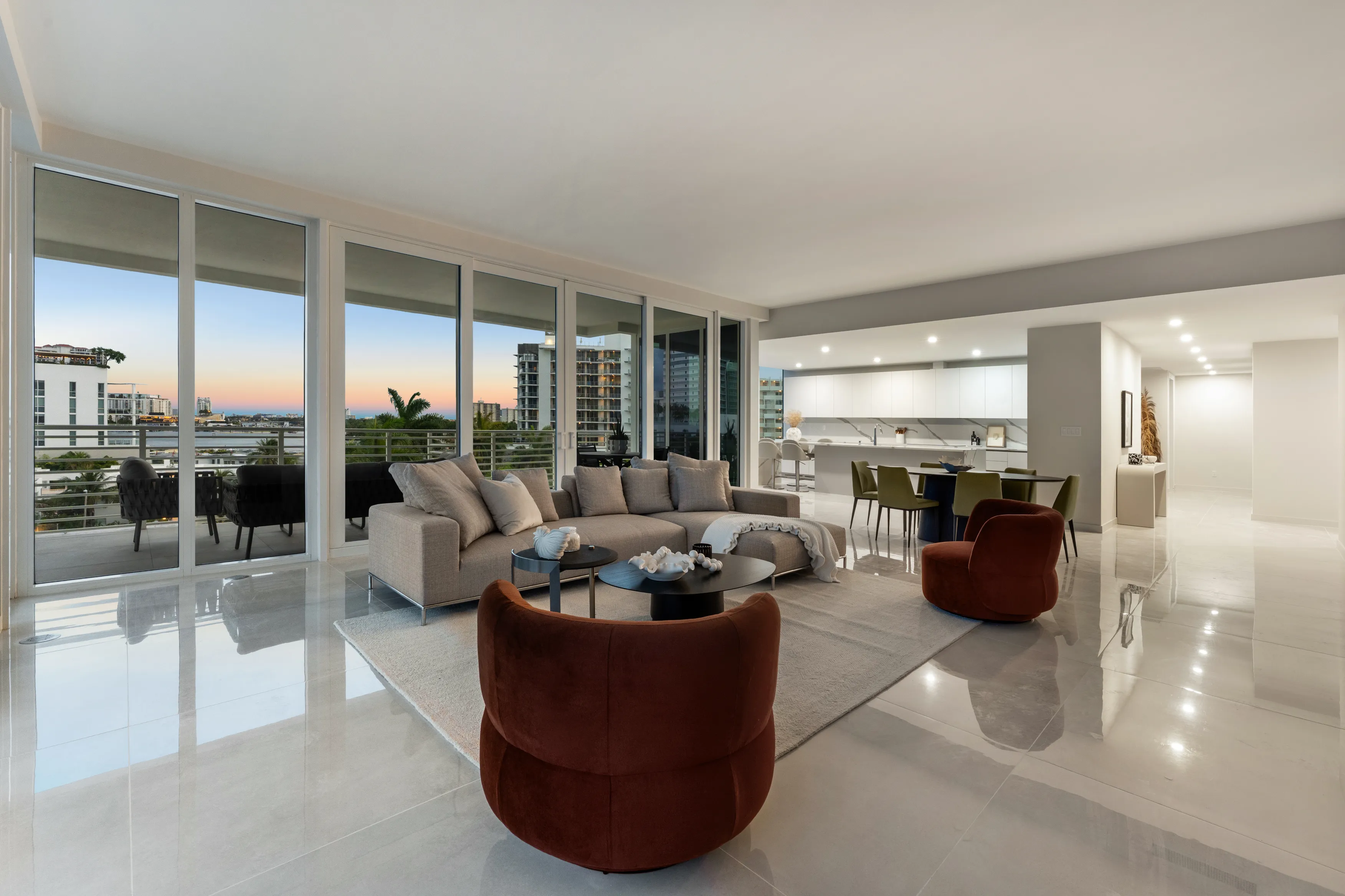 A modern living room featuring a large window with a view of the city skyline.