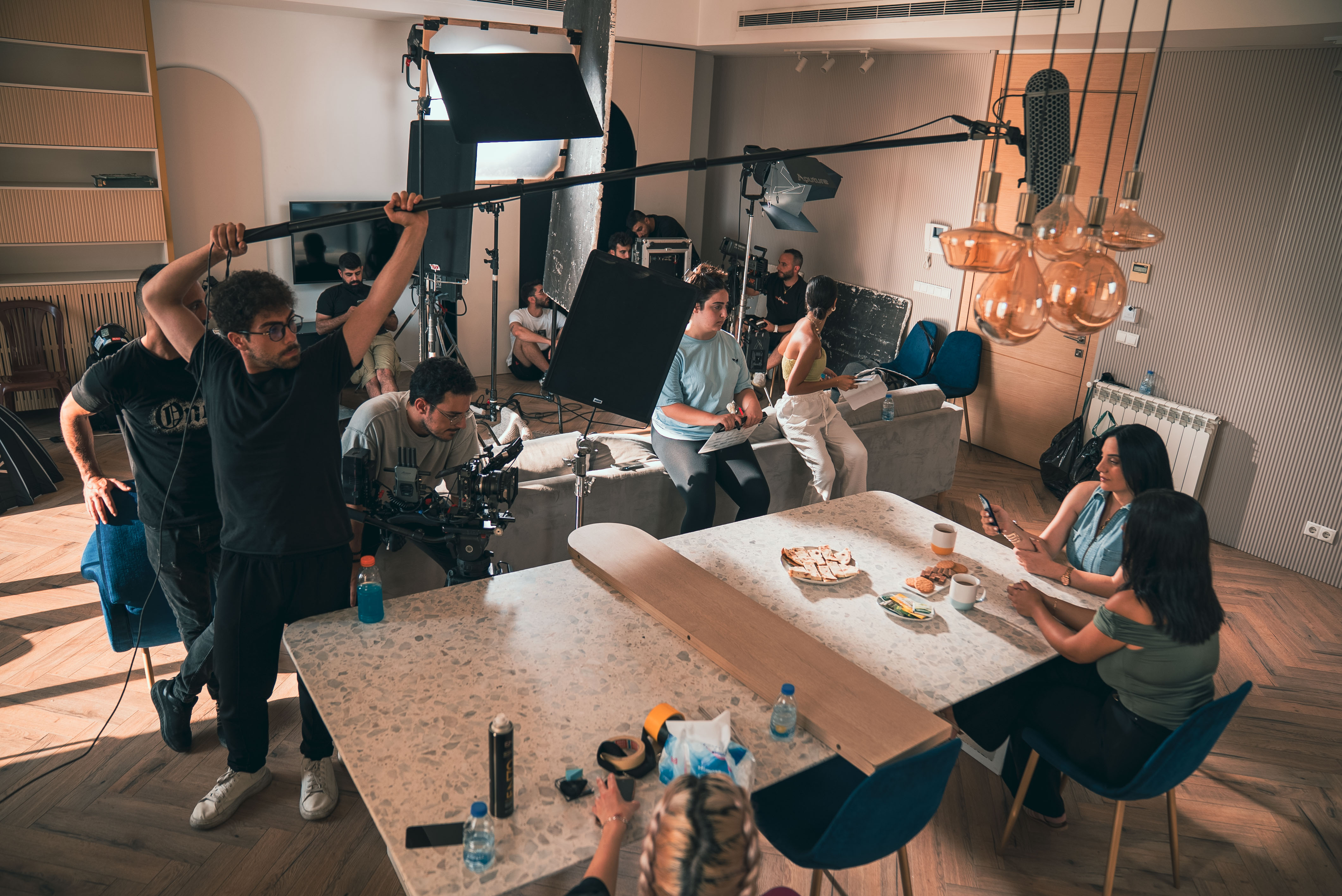 Modern red brick apartment or office building viewed from below against a blue sky, showcasing its geometric architecture with evenly spaced windows and balconies.