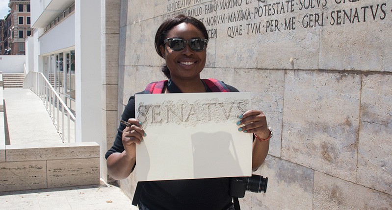 woman holding paper in front of wall