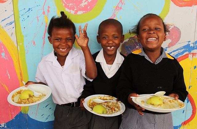 a group of children standing around each other