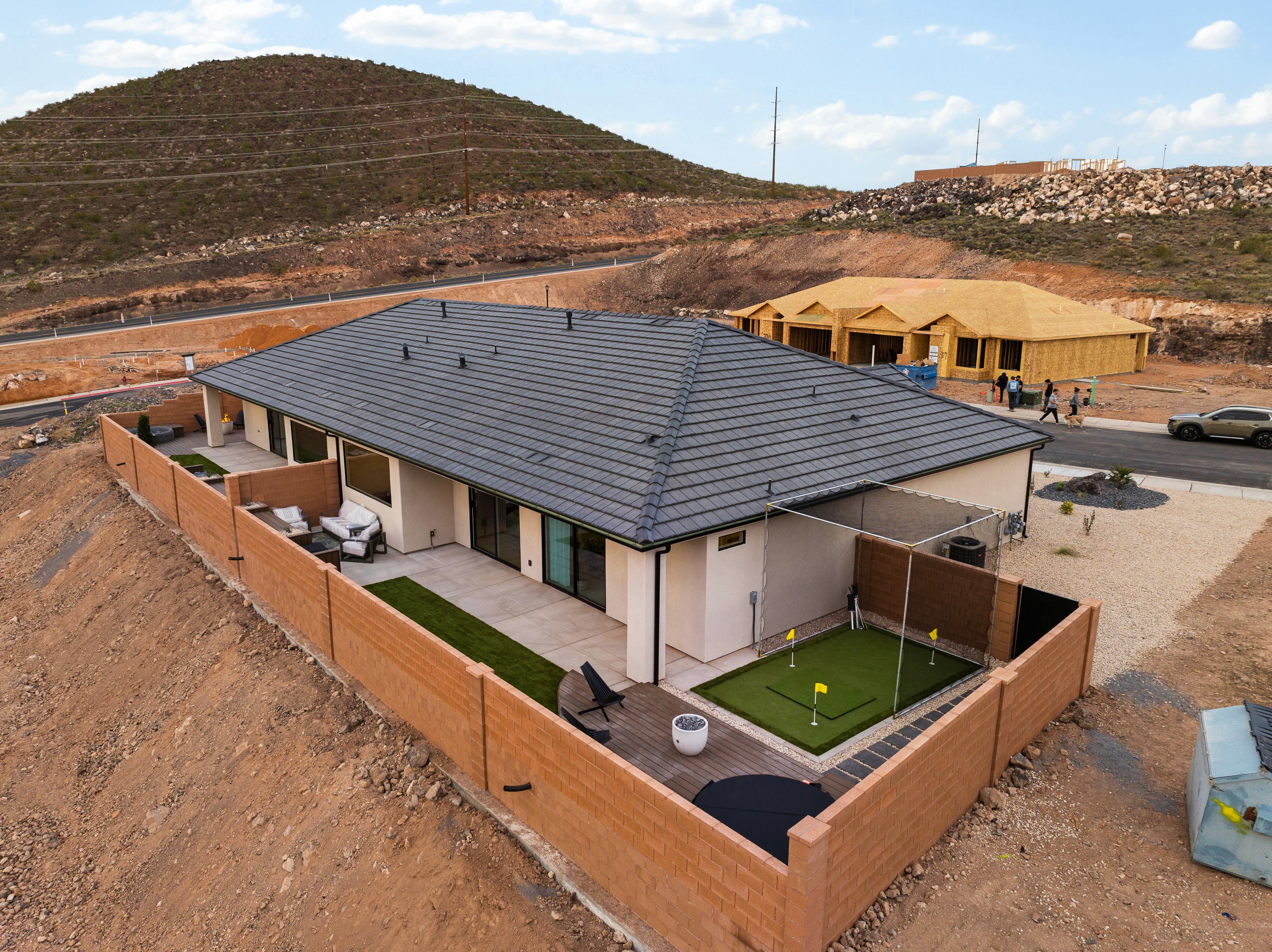 Aerial view of the backyard of The Painted Horizon in Hurricane, Utah featuring a hot tub and putting green designed for recreation and relaxation.