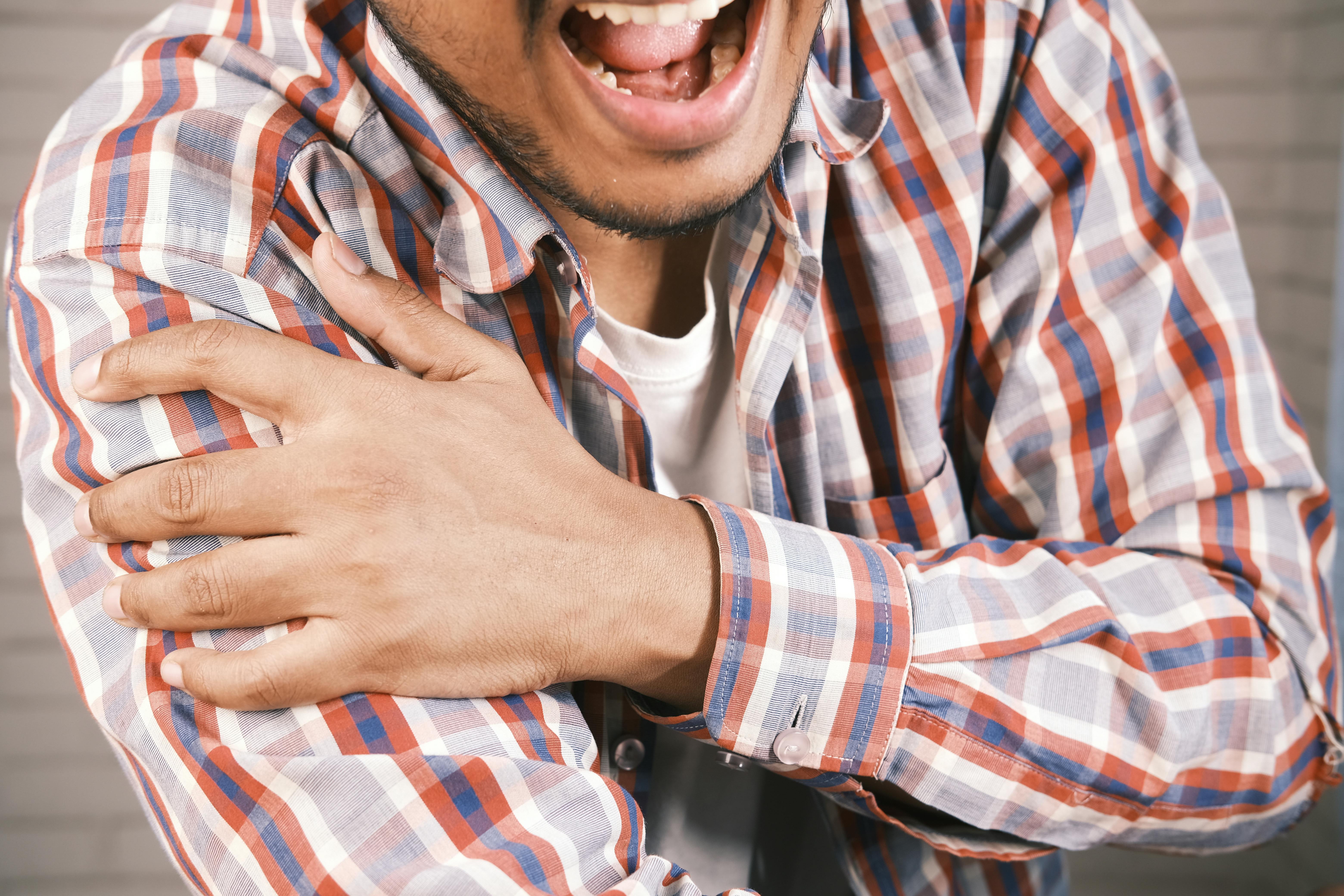 close-up-of-a-man-in-plaid-shirt-experiencing-shoulder-pain,-grasping-his-arm. - towfiqu-barbhuiya (pexels)