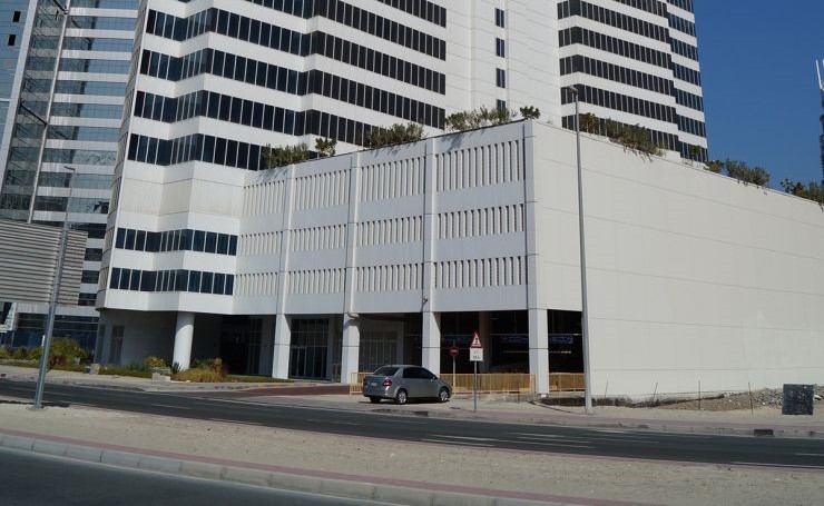 Architectural detail of a white and glass commercial building, ideal for investment via professional realty agents.