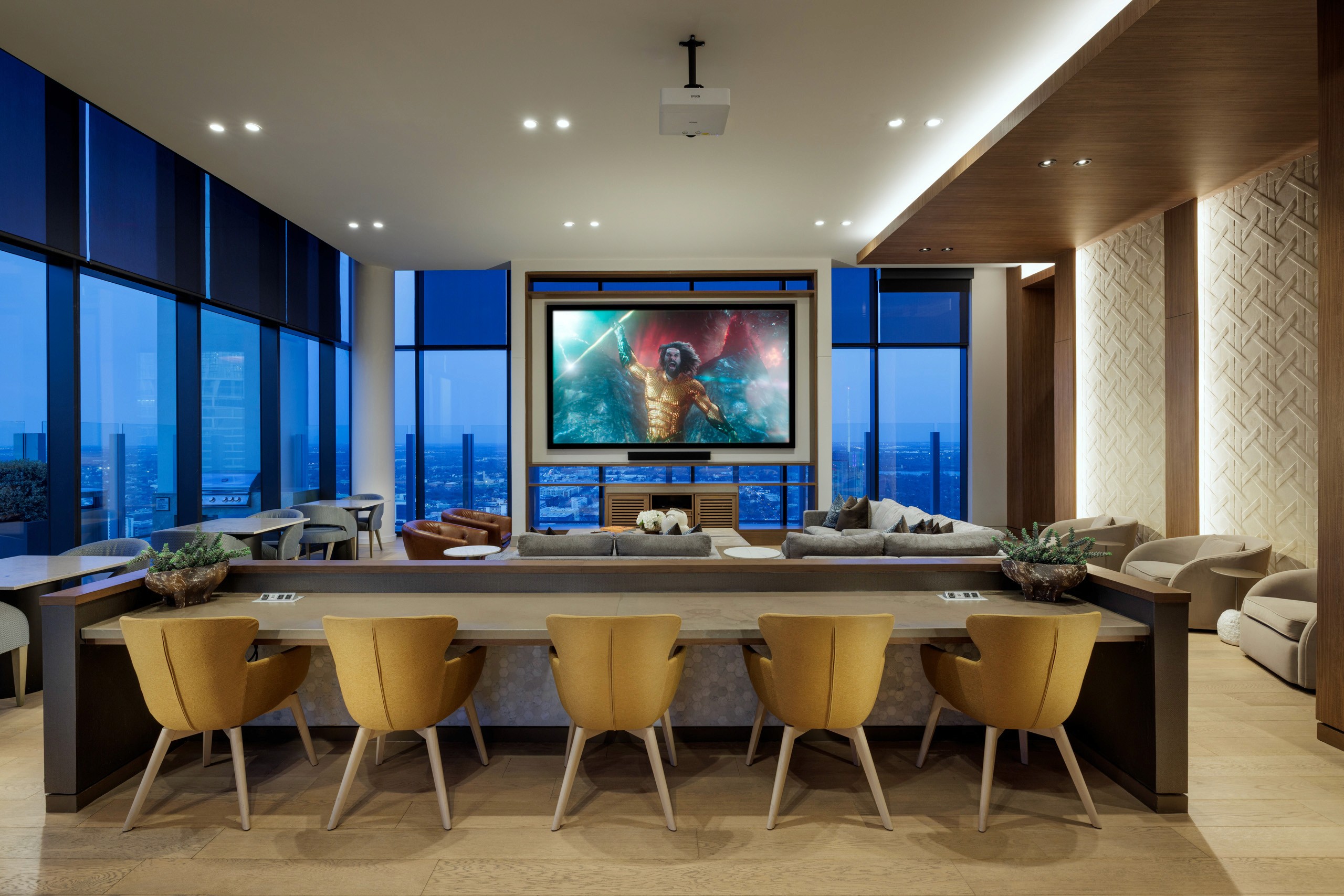 Modern lounge with large screen, cityscape view