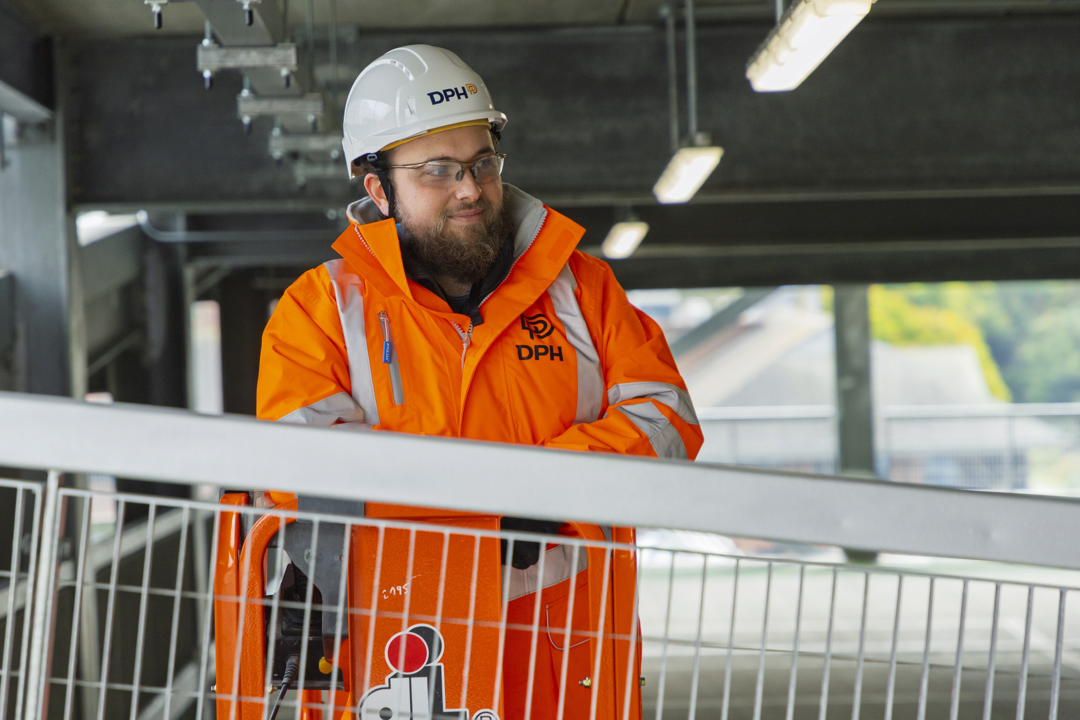 Modern glass buildings with illuminated facades and trees on a rainy day
