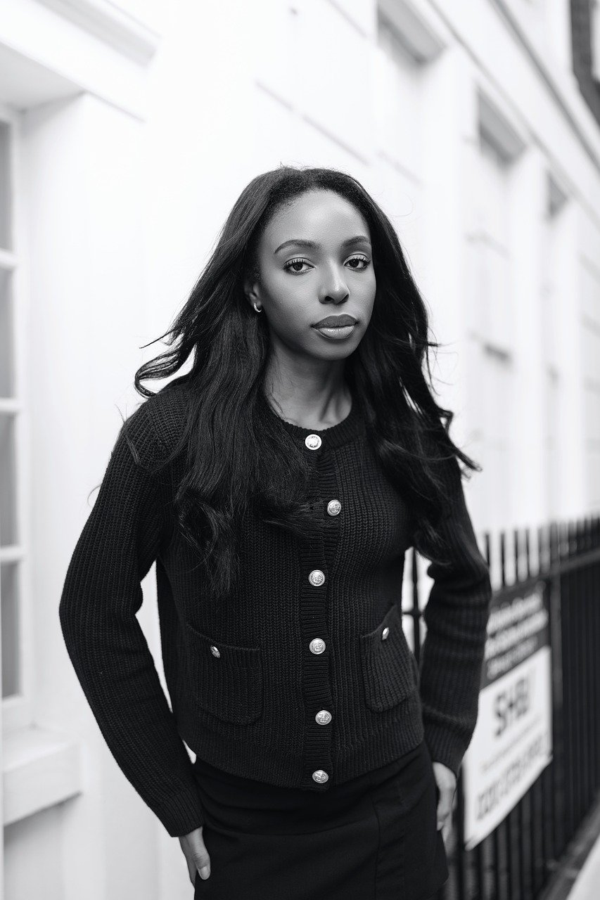 man in white sweater holding round mirror