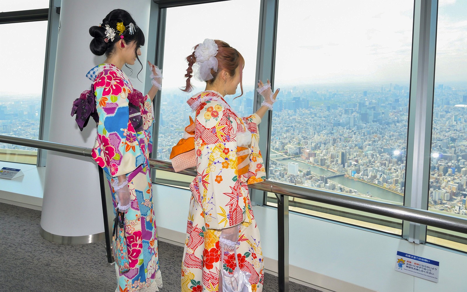 Visitantes en kimonos tradicionales en la Tokyo Skytree, Japón, disfrutando de vistas panorámicas de la ciudad.